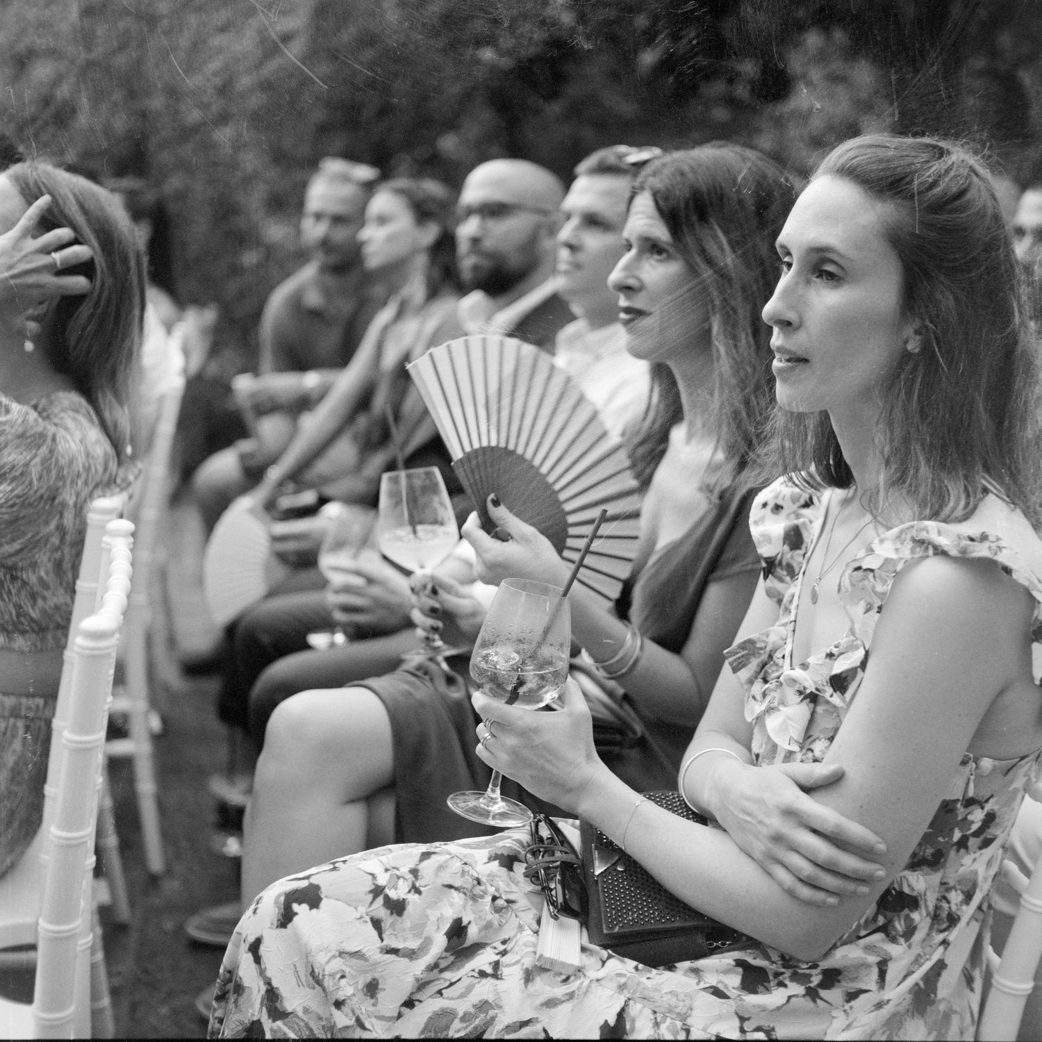 Black and white photo of a crowd watching and recording something with their phones and cameras outdoors.