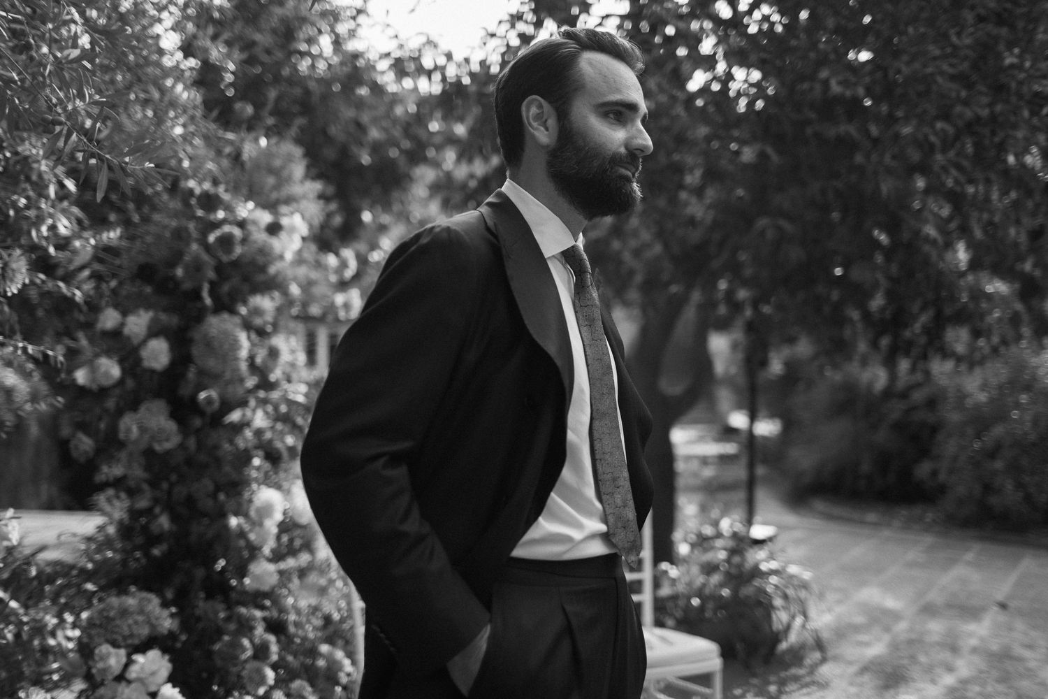 Black and white wedding photo series showing intimate moments between newlyweds in a garden setting.