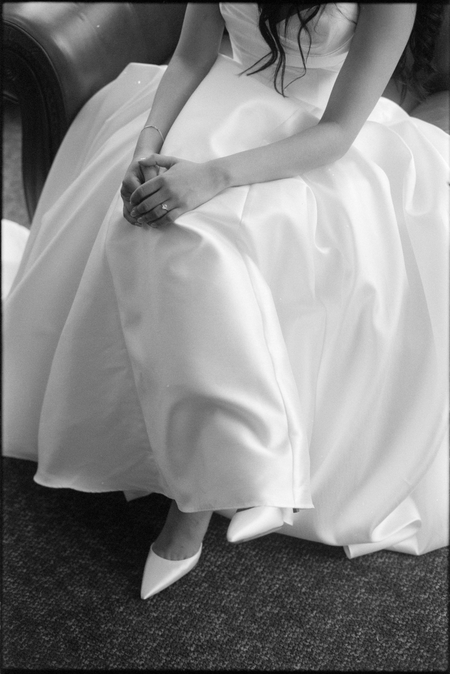 Close-up series showing the flowing movement of a white wedding dress against dark carpet.