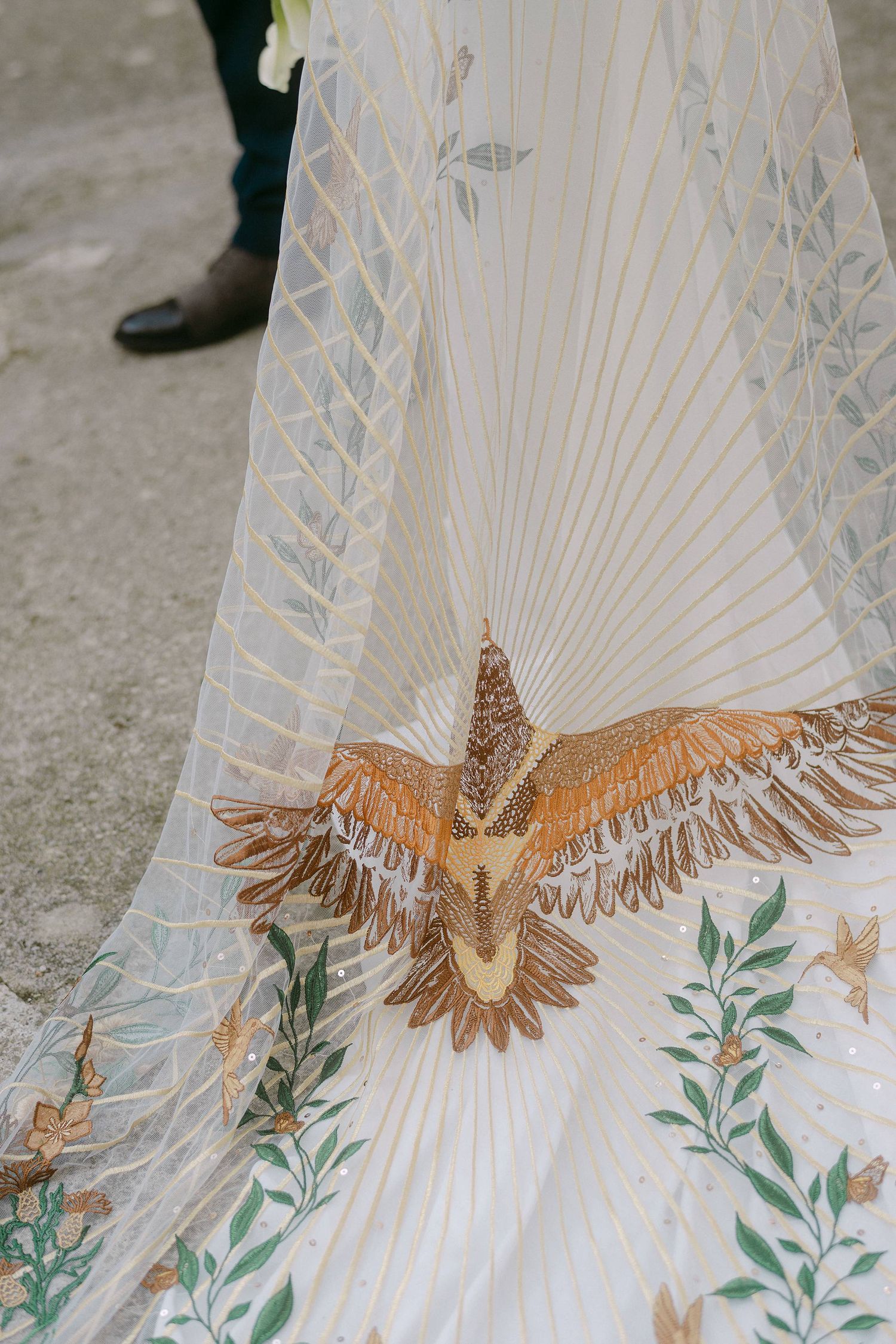 A series of images showing a decorative fan with an embroidered golden bird and floral design on white fabric.