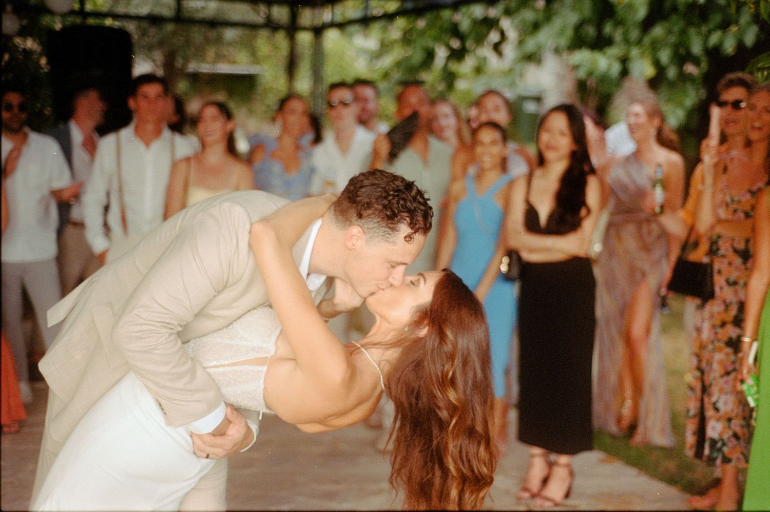 Wedding reception guests dance and celebrate on a dance floor during an evening celebration.