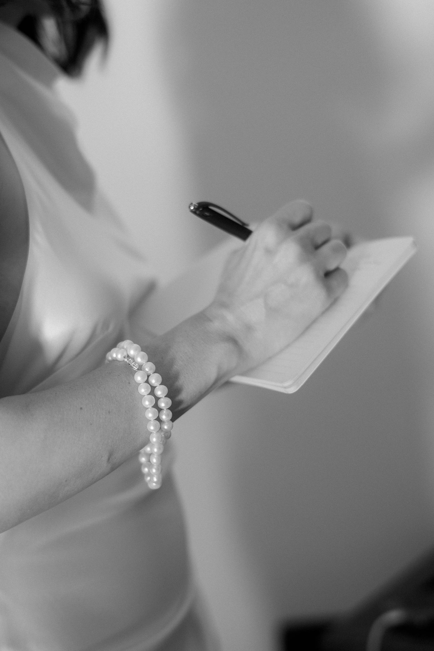 A series of black and white close-up photographs showing a delicate pearl bracelet from different angles.