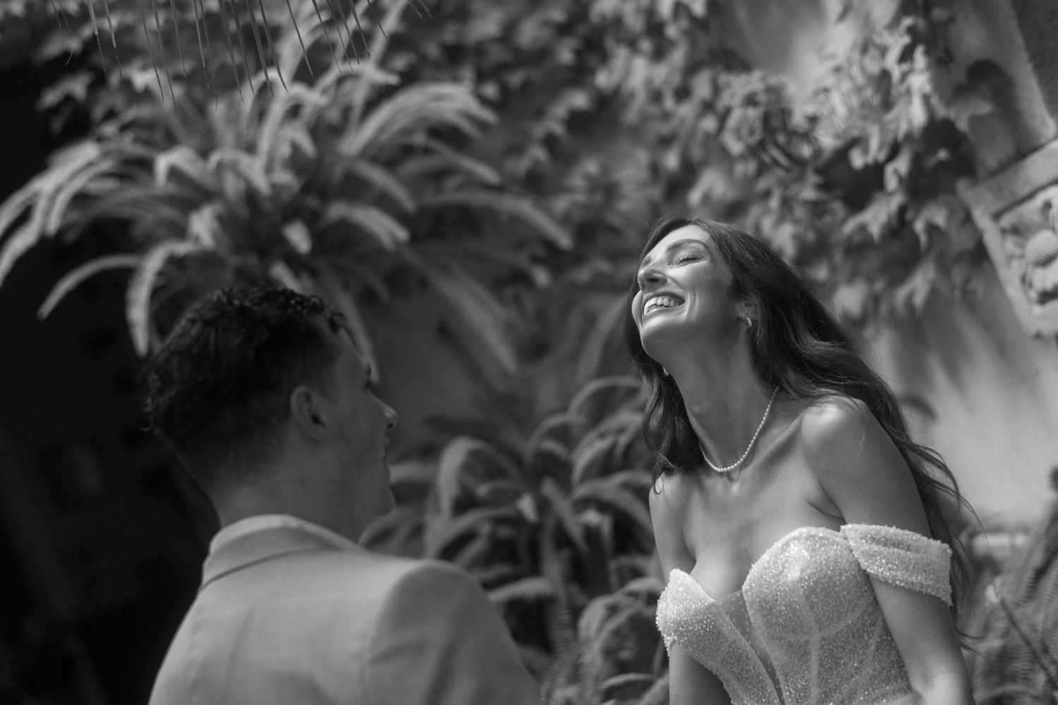 A collection of black and white portraits showing joyful expressions and laughter in natural outdoor settings.