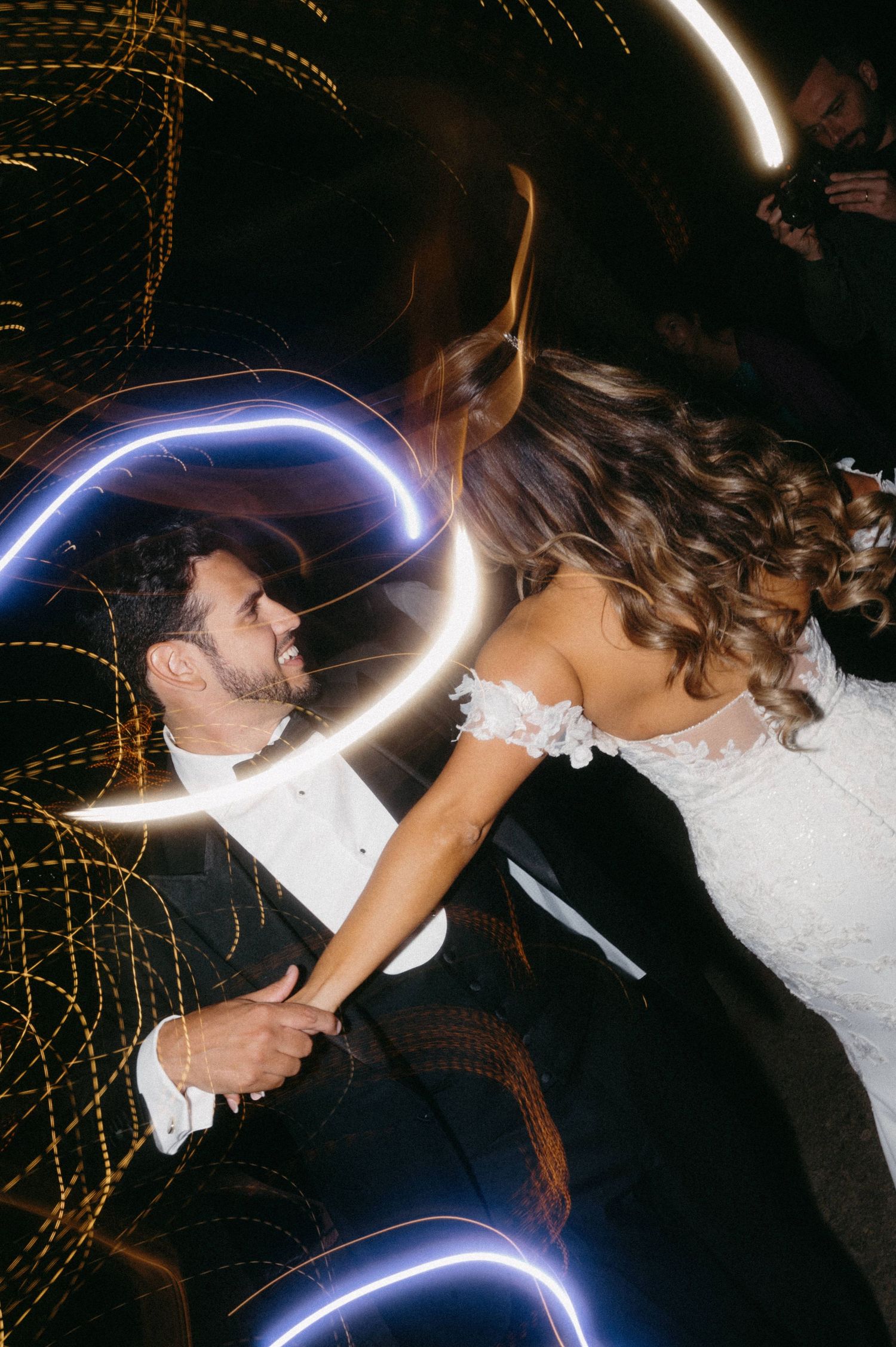 A sequence of motion-blurred photos showing a couple sharing a kiss with light trails creating a dynamic effect.
