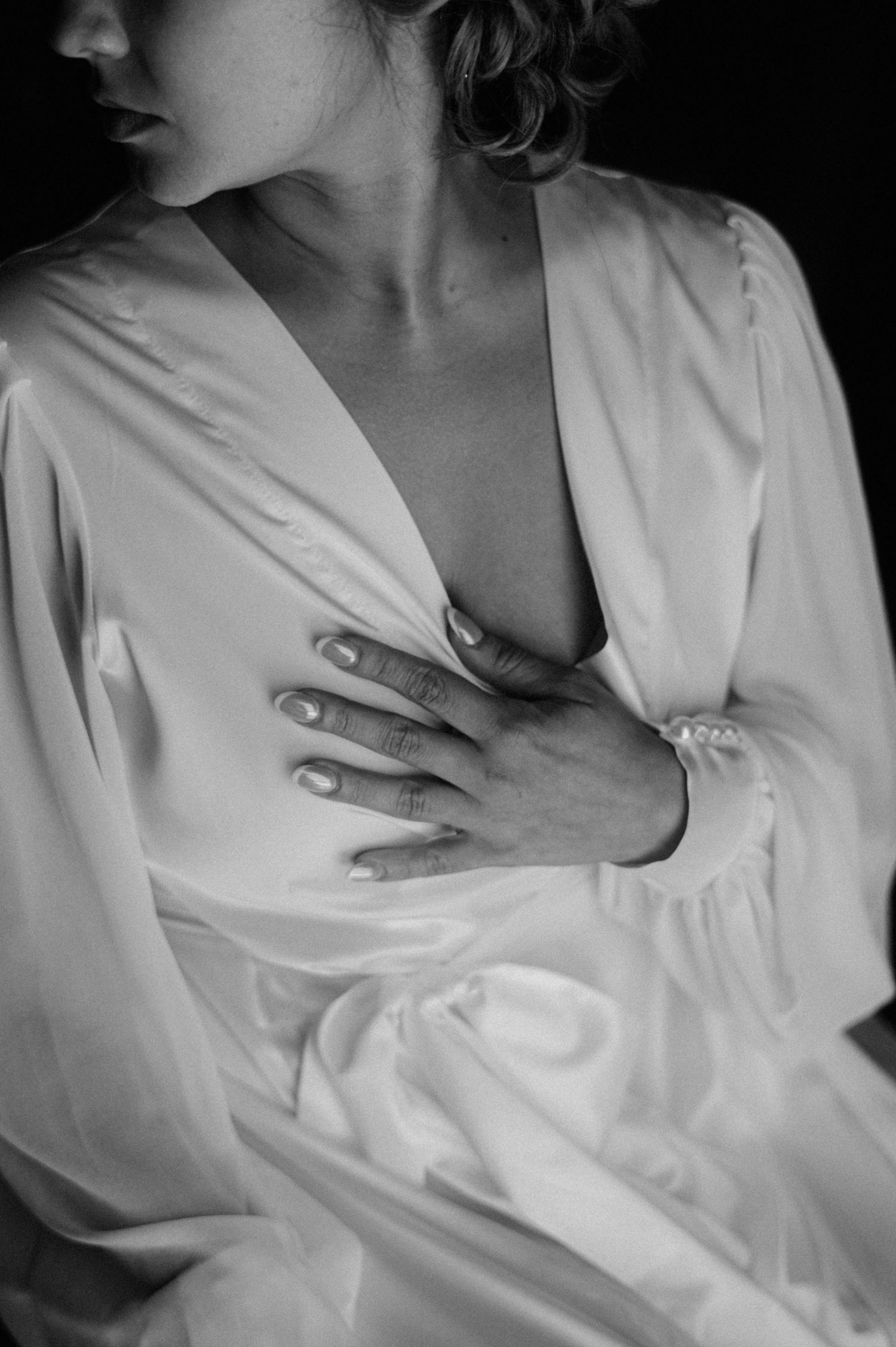 A series of black and white photographs showing hands resting on a white shirt in different artistic poses.