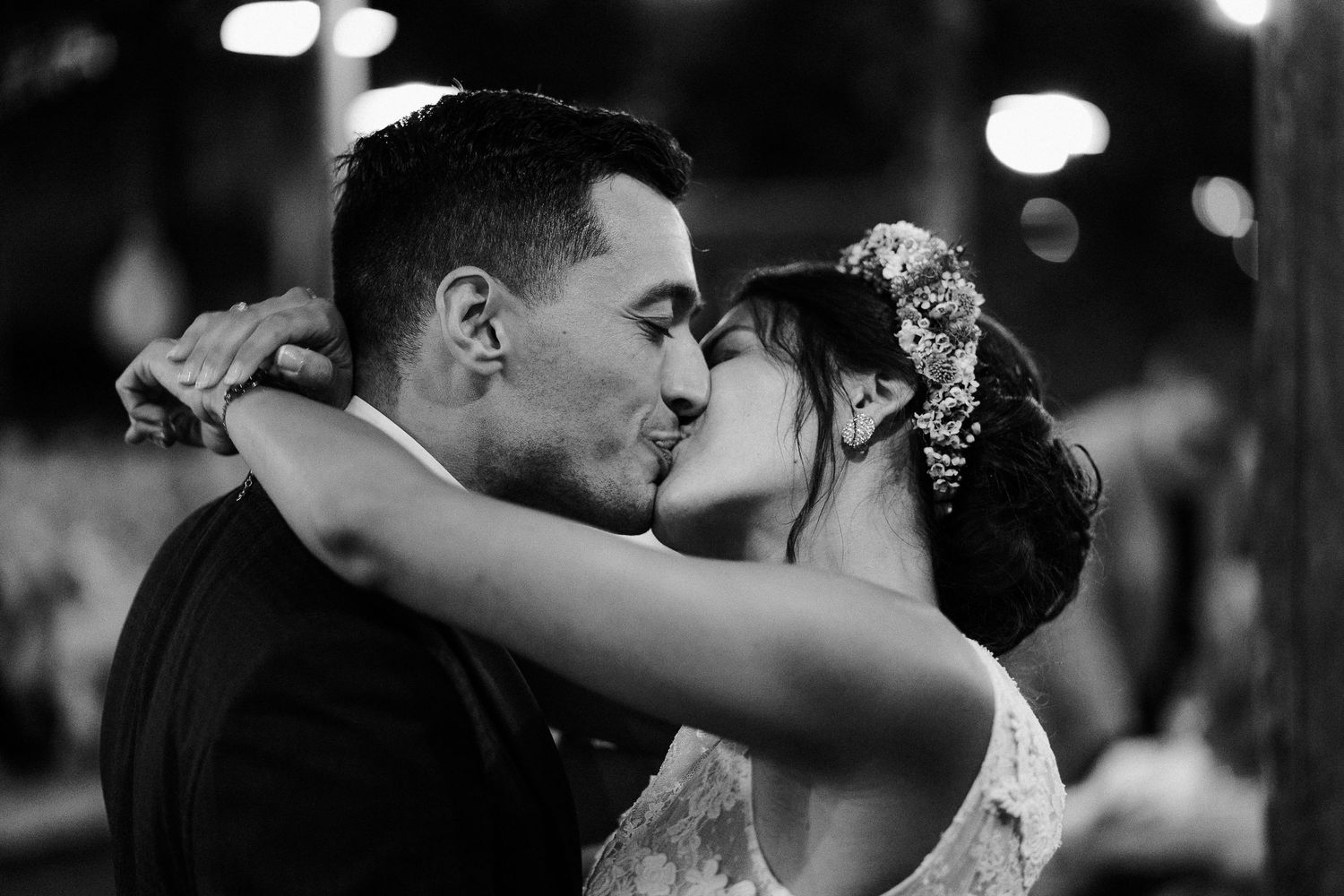 A tender black and white photograph captures an intimate wedding dance moment between newlyweds at their reception.