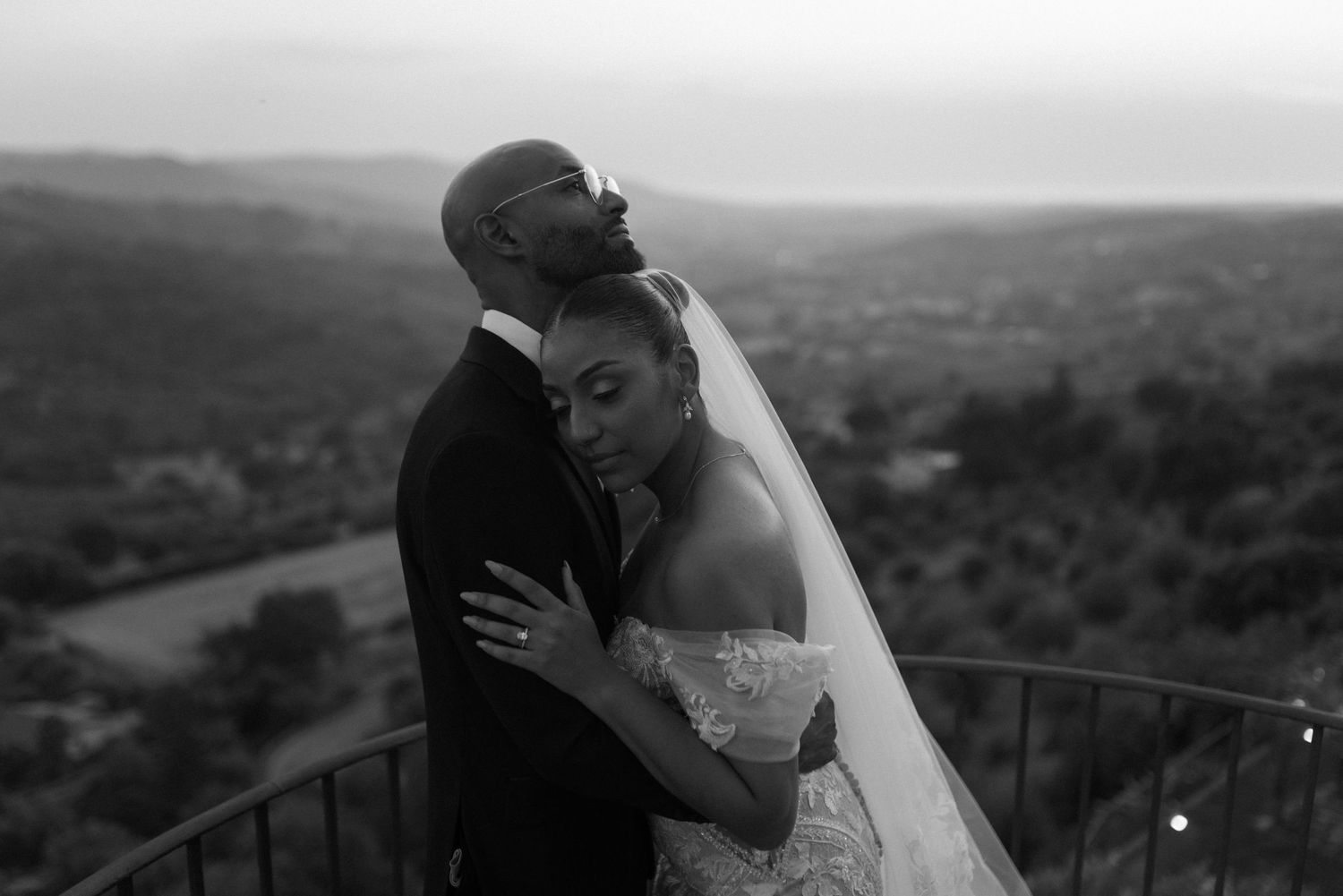 Black and white wedding photos show romantic moments between newlyweds against scenic mountain landscape views.