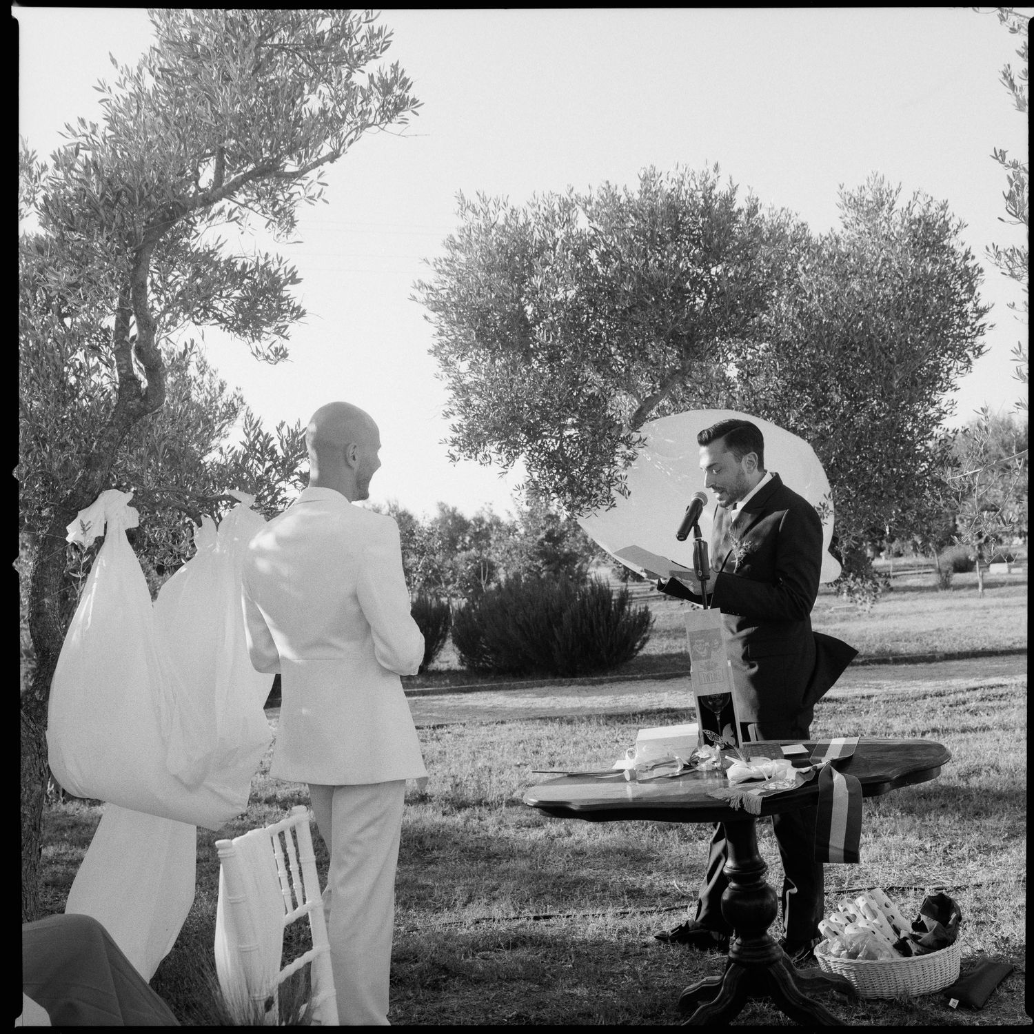 A sequence of black and white photographs showing two figures in white robes practicing martial arts moves outdoors.