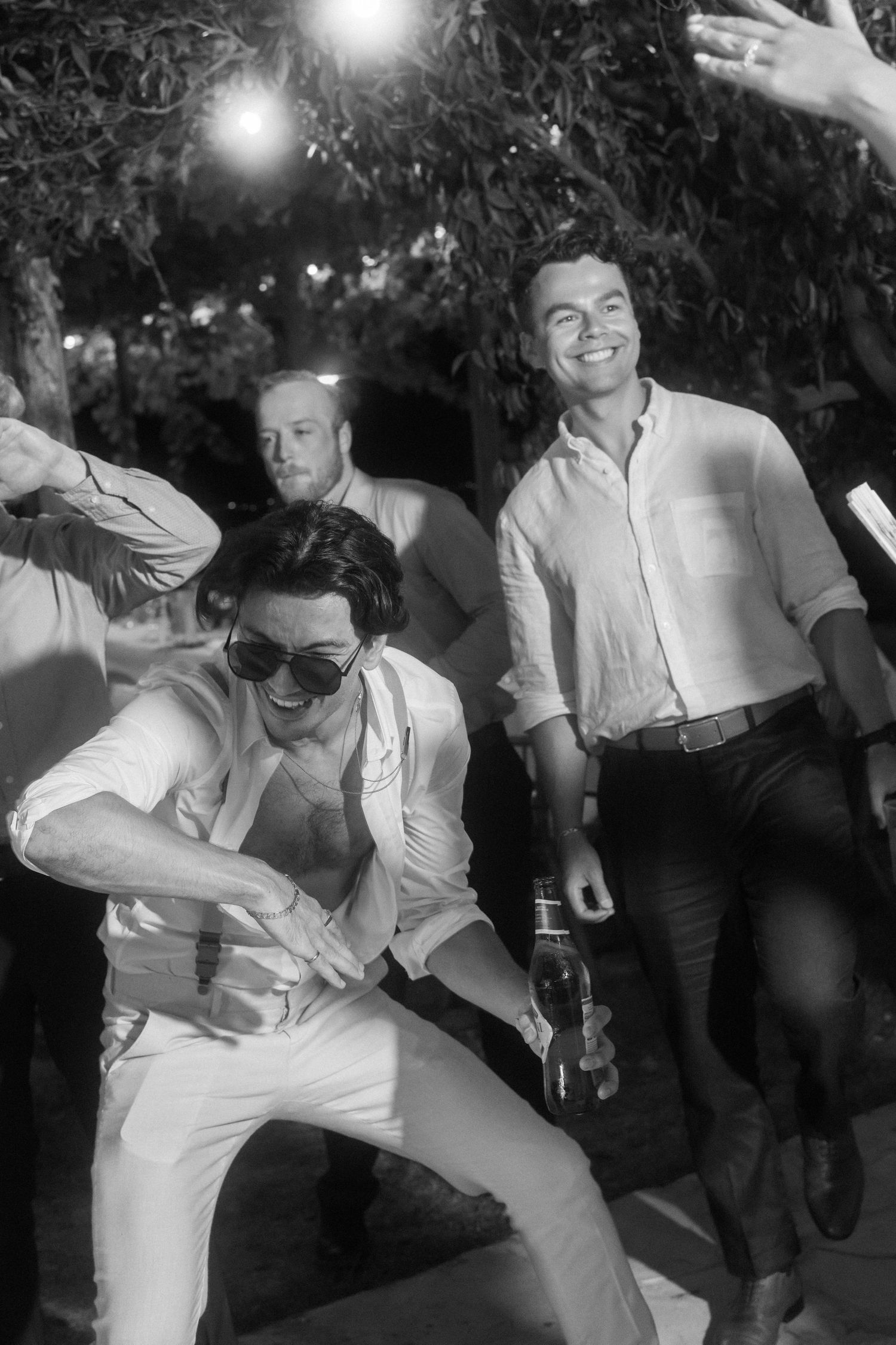 A sequence of black and white photos shows a person in white dancing energetically at a party or celebration.