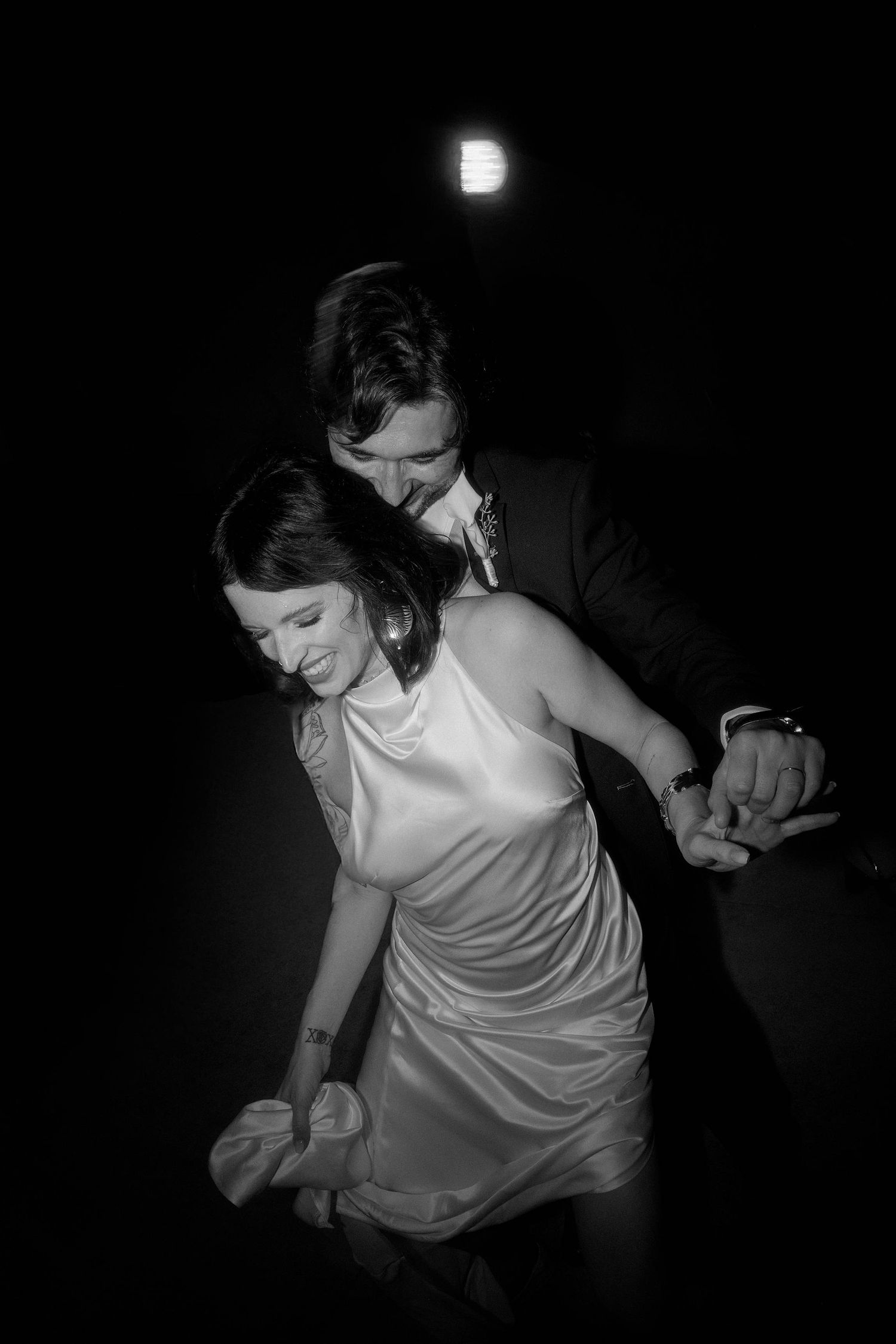 A series of black and white photos showing someone in a white dress dancing in dark lighting conditions.