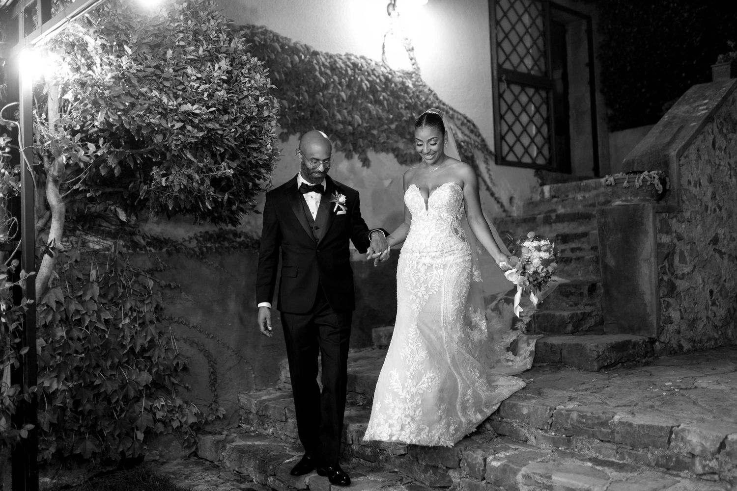 Black and white wedding photography series showing romantic couple portraits against stone walls and garden settings.