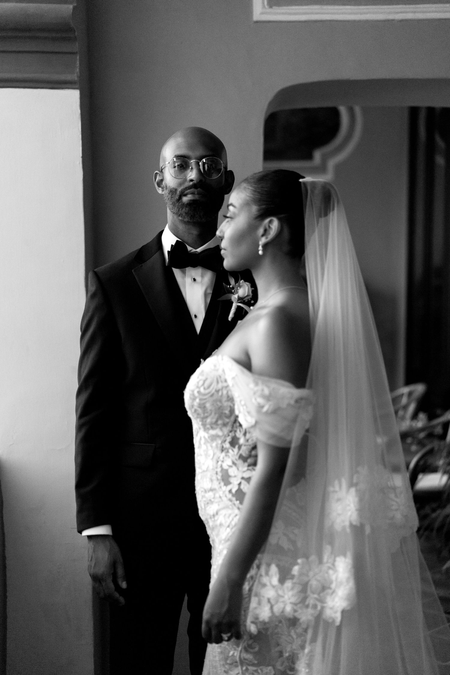 A black and white photo series showing tender moments between a bride and groom on their wedding day.