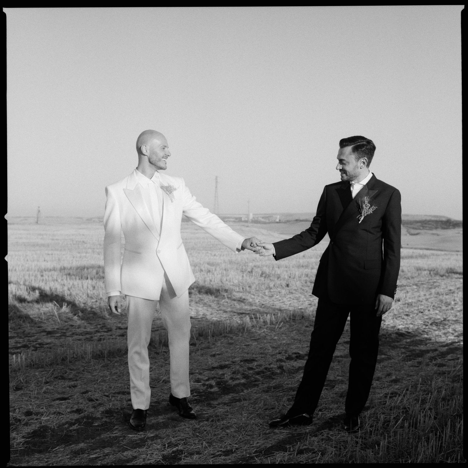 A surreal black and white photo sequence showing a person in dark suit interacting with a floating white garment in a field.