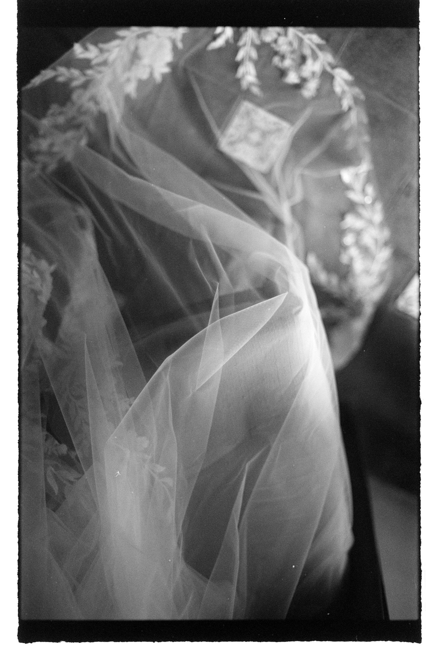 A series of black and white photographs showing delicate layers of flowing sheer fabric creating ethereal textures.