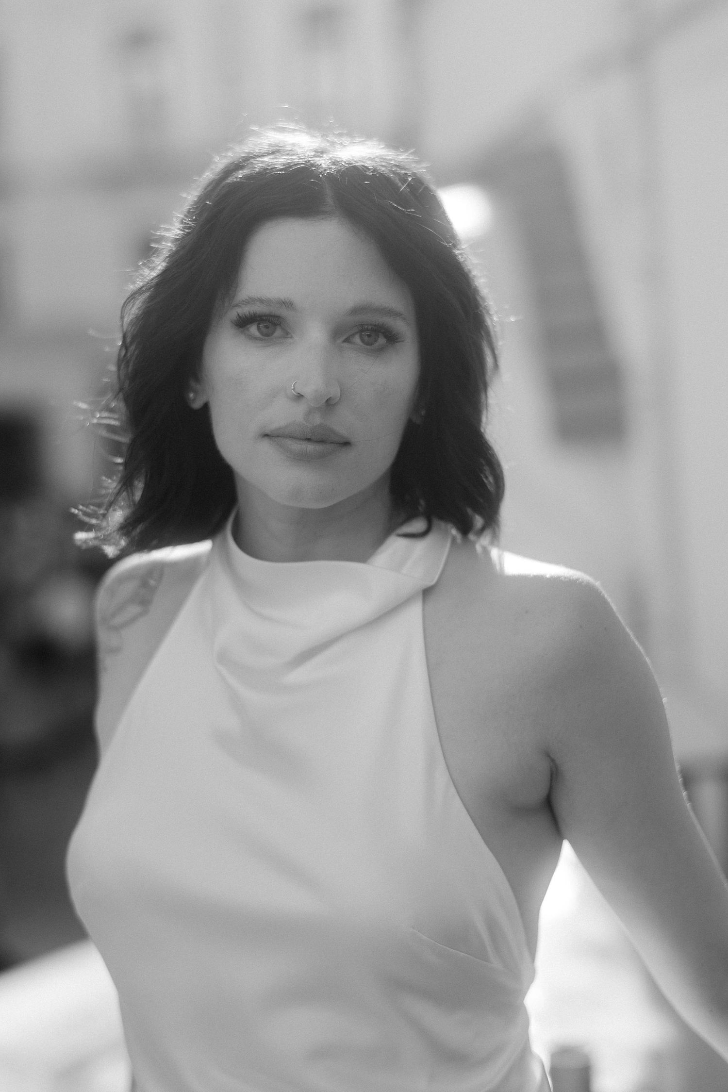A sequence of black and white headshots showing a woman in a white sleeveless top against a light background.