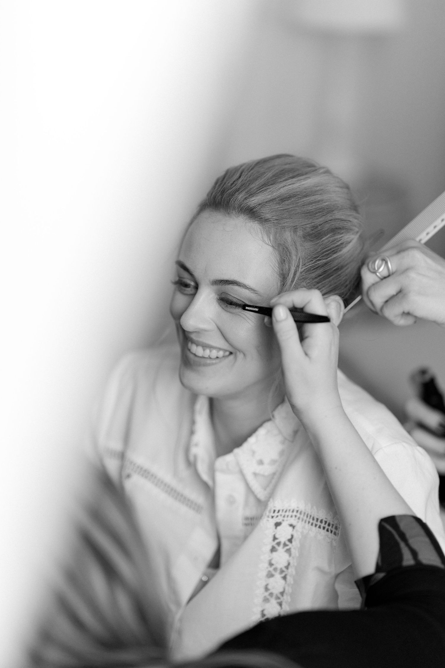 Black and white photo sequence showing a bride getting makeup applied before her wedding ceremony.