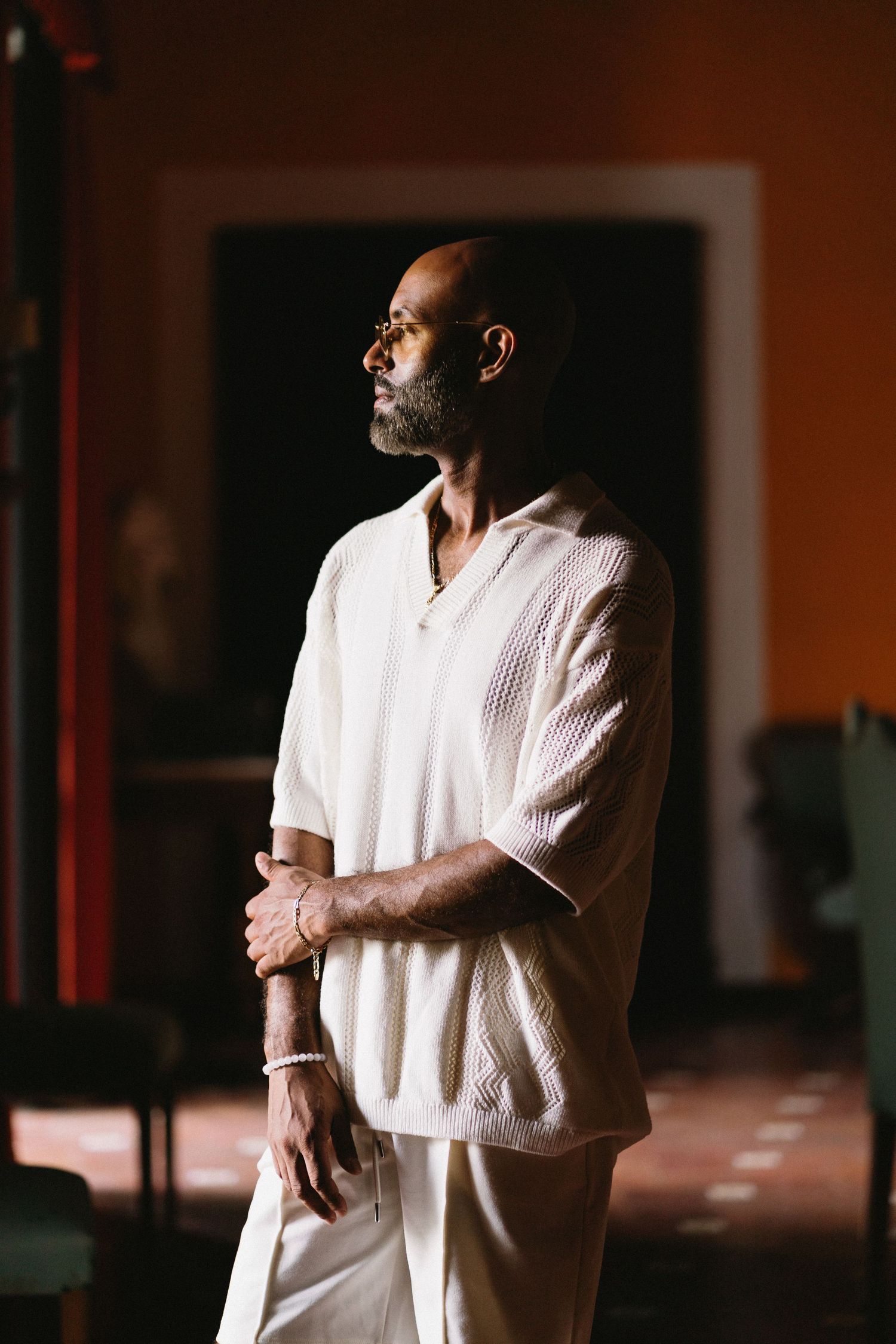 A person in a white shirt stands in dramatic lighting creating a series of moody portrait compositions.