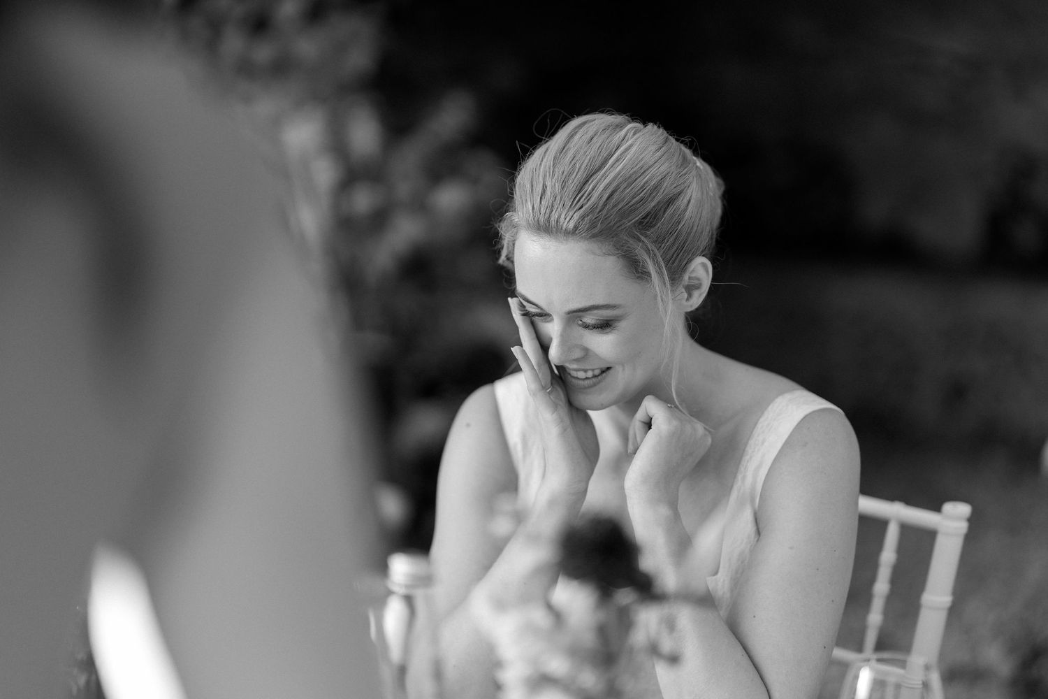 A series of black and white wedding photos showing emotional moments during a ceremony and reception.