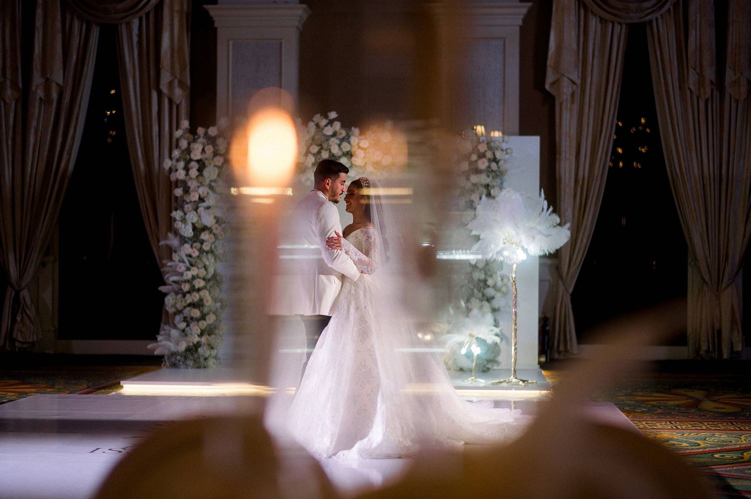 Elegant wedding venue with romantic lighting and white floral arrangements creating a dreamy atmosphere.