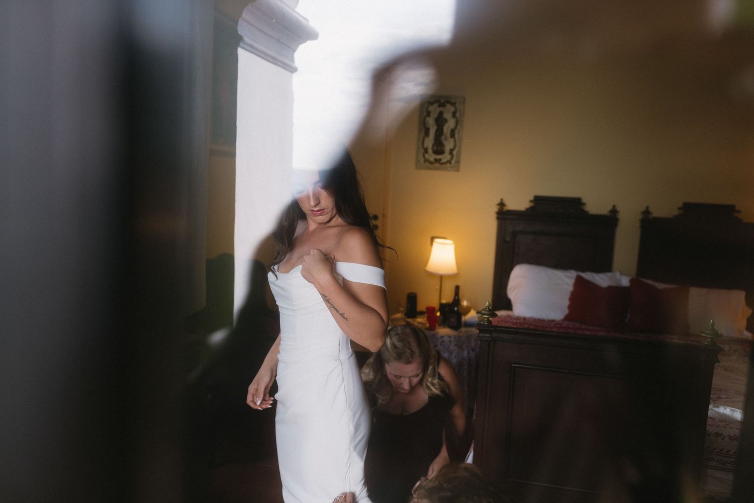 A couple shares their first dance at a wedding reception in a dimly lit room.
