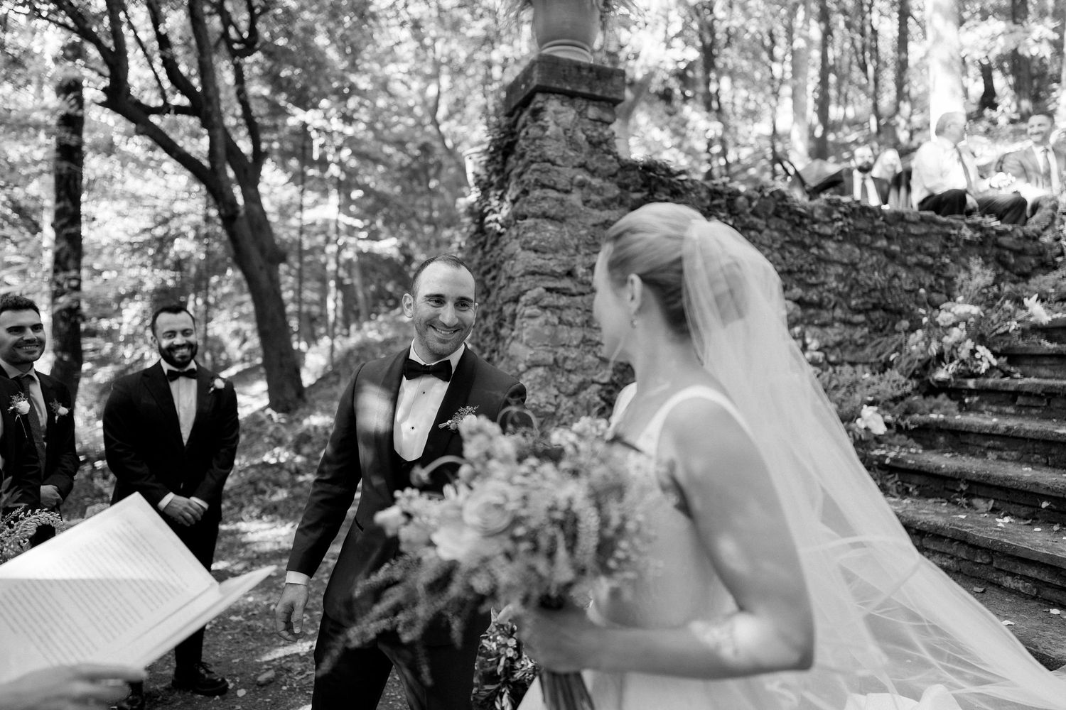 A collection of black and white wedding photographs showing couples in romantic outdoor settings among trees and nature.