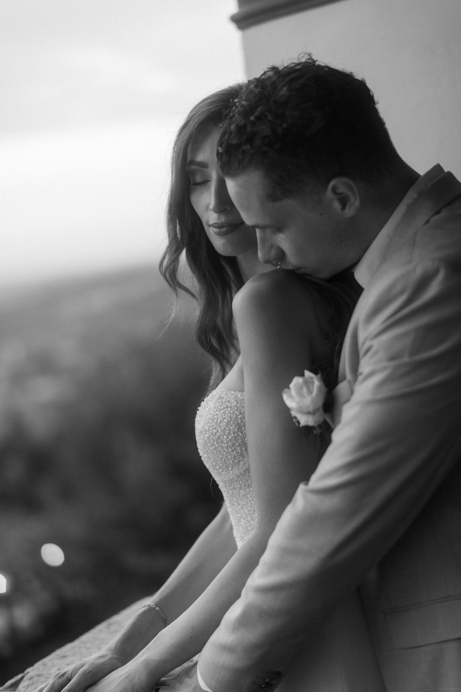 A romantic black and white wedding photo sequence shows a couple embracing on a balcony at sunset.
