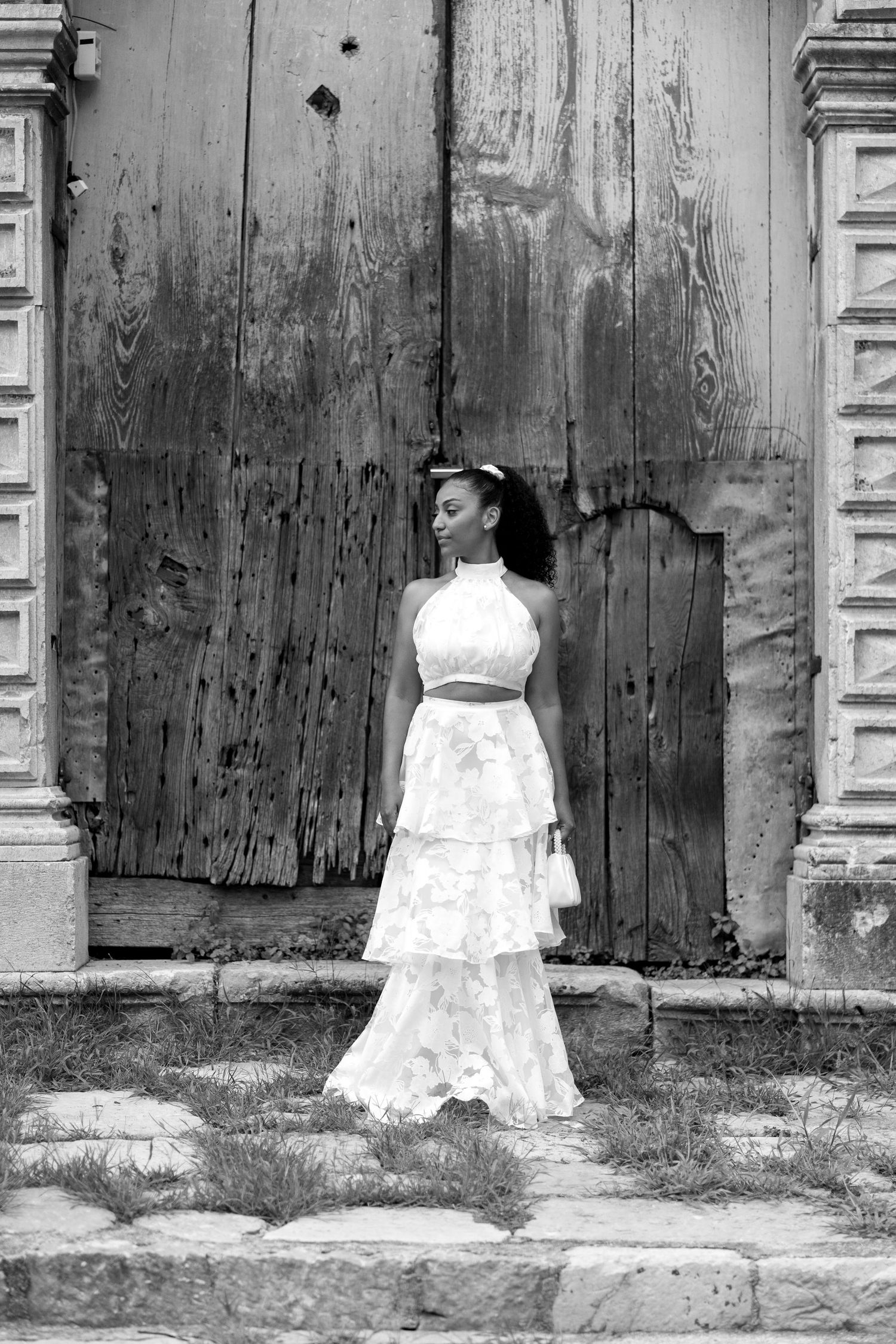 Black and white artistic photo series showing white dresses against weathered wooden walls and columns.