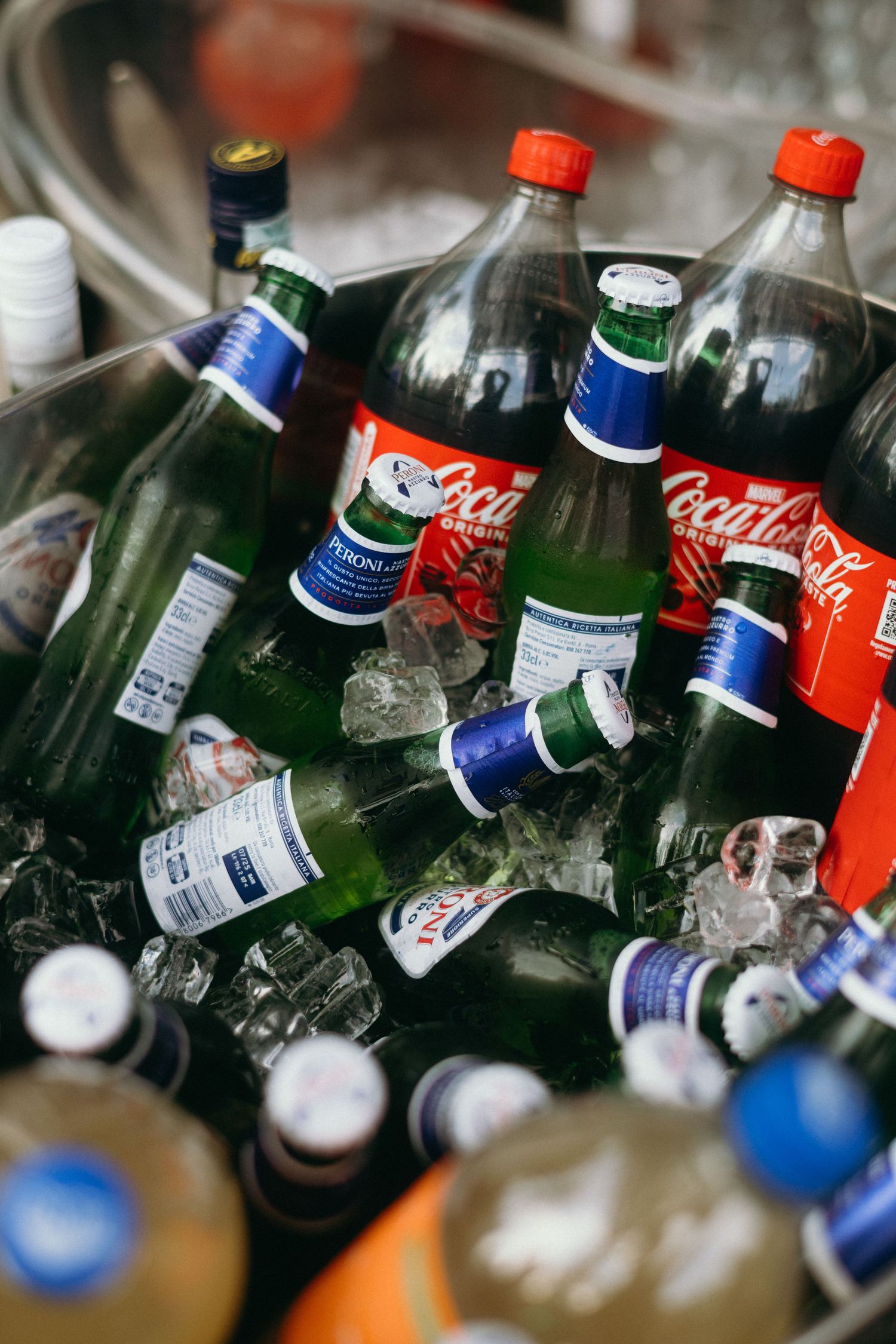 Bottles of Coca-Cola and Pepsi chilling in ice at a party or event.