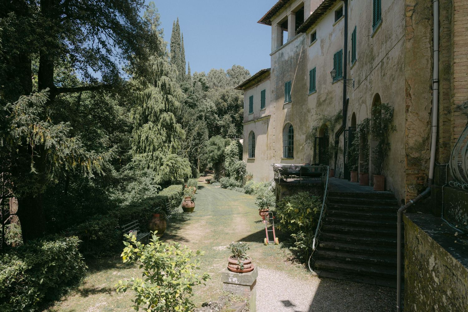 A series of old stone buildings and narrow alleyways in a rustic Mediterranean village under bright sunlight.