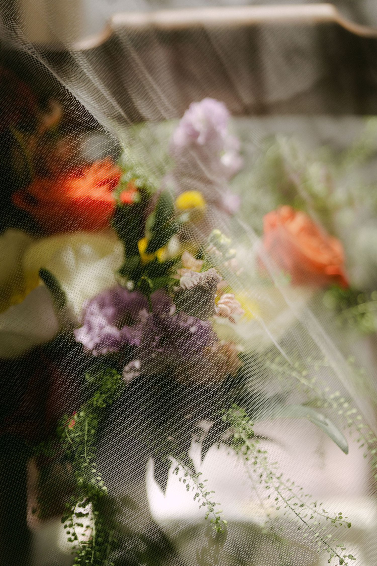 Abstract floral arrangement with soft focus blending colorful flowers and greenery in dreamy ethereal lighting.