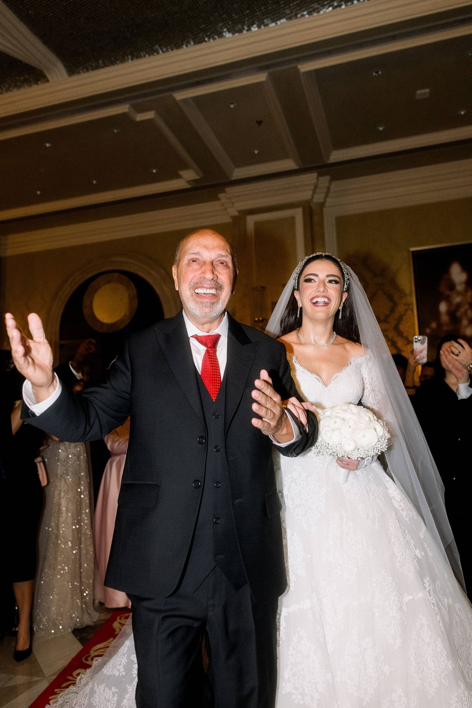 A couple celebrates joyfully during their wedding reception in an elegant indoor venue.
