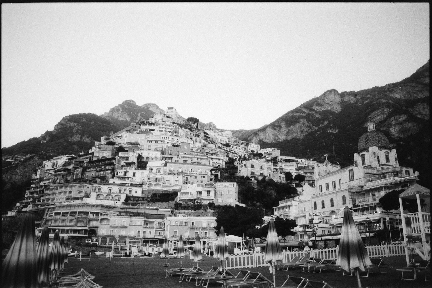 Black and white landscape photo of hillside buildings and houses overlooking the Amalfi Coast in Italy.