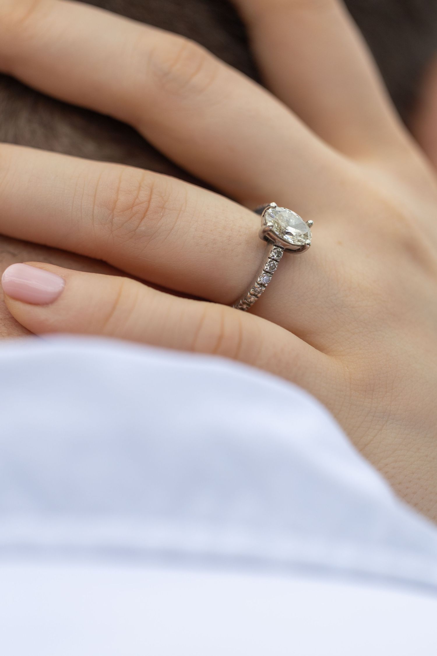 Close-up of a diamond solitaire engagement ring on a woman's finger.