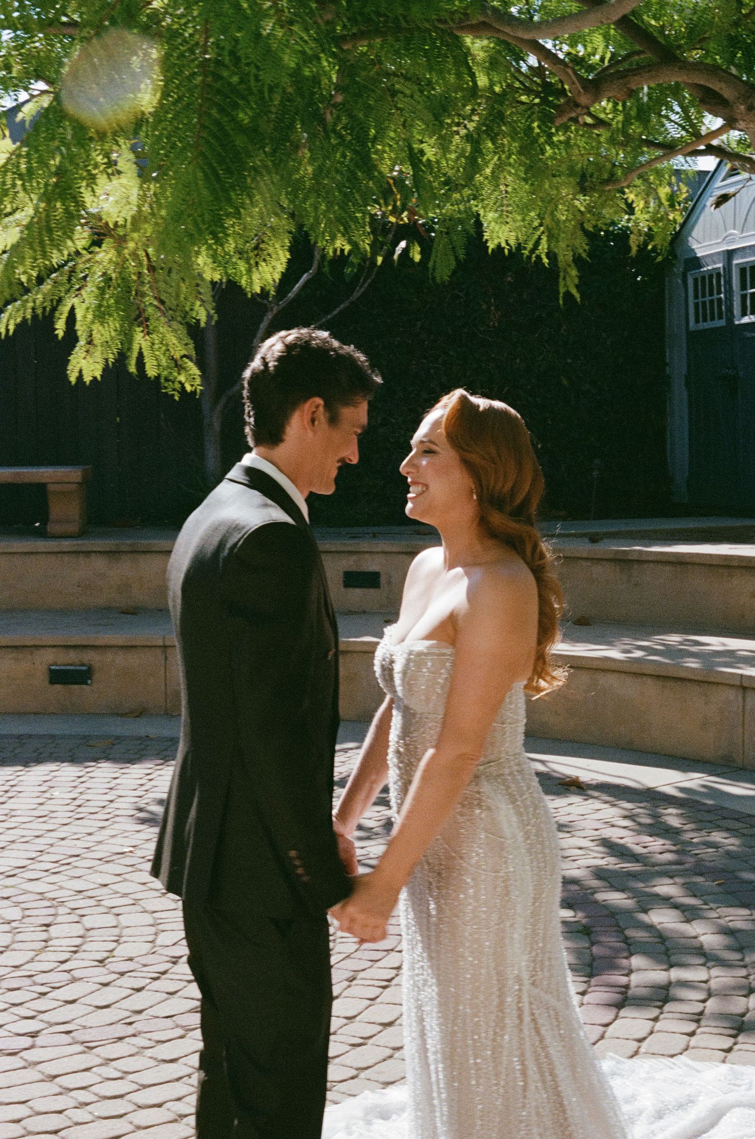 Outdoor wedding moments under lush green trees on a sunny afternoon.