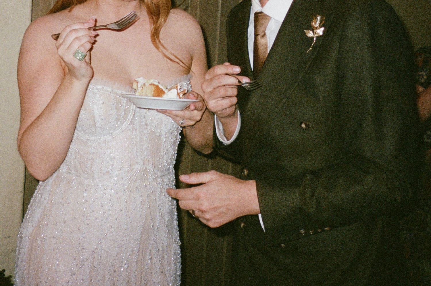 Elegant couple in formal wedding attire toasting with champagne flutes at a celebration.