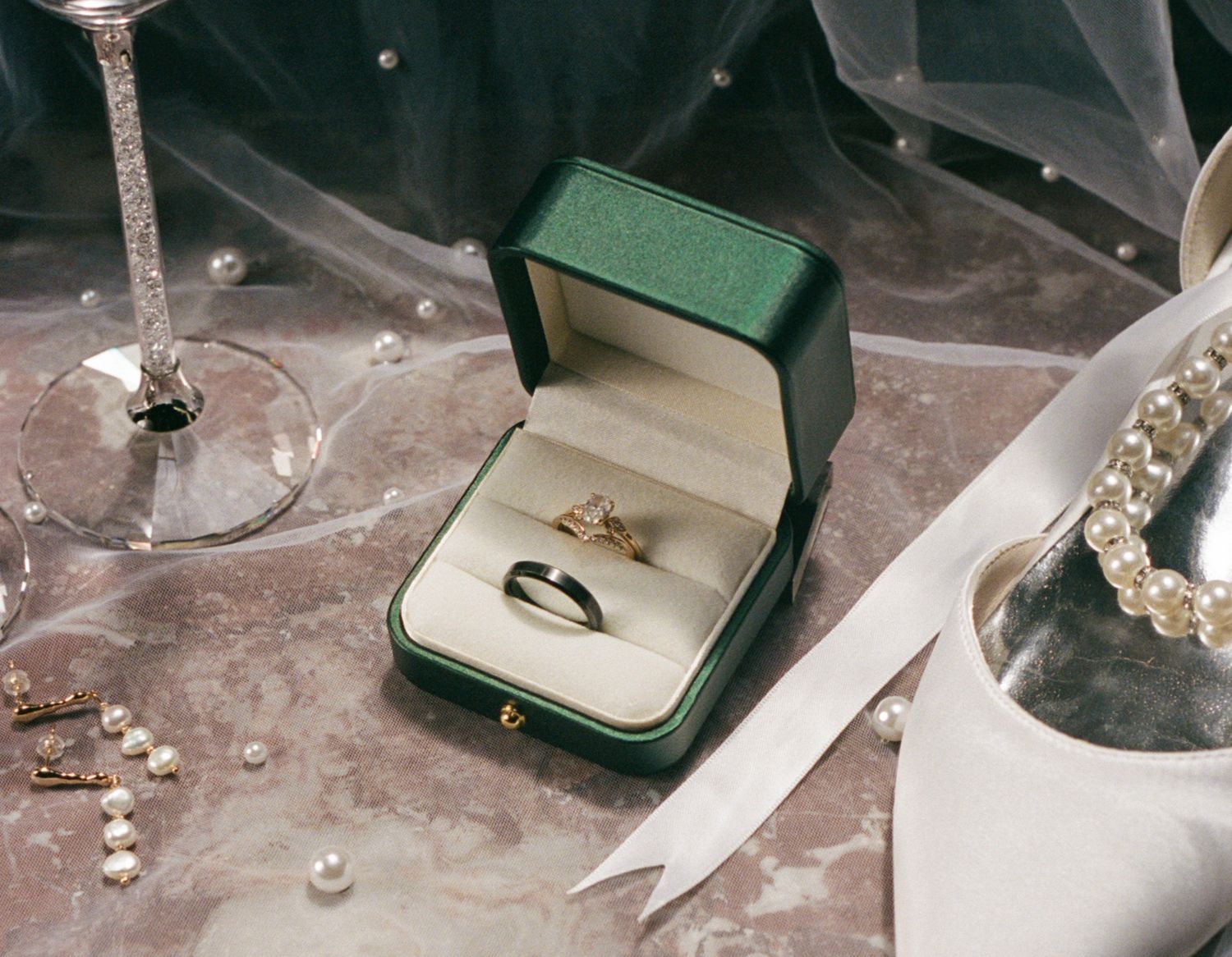 Collection of wedding rings and jewelry displayed on a marble surface.
