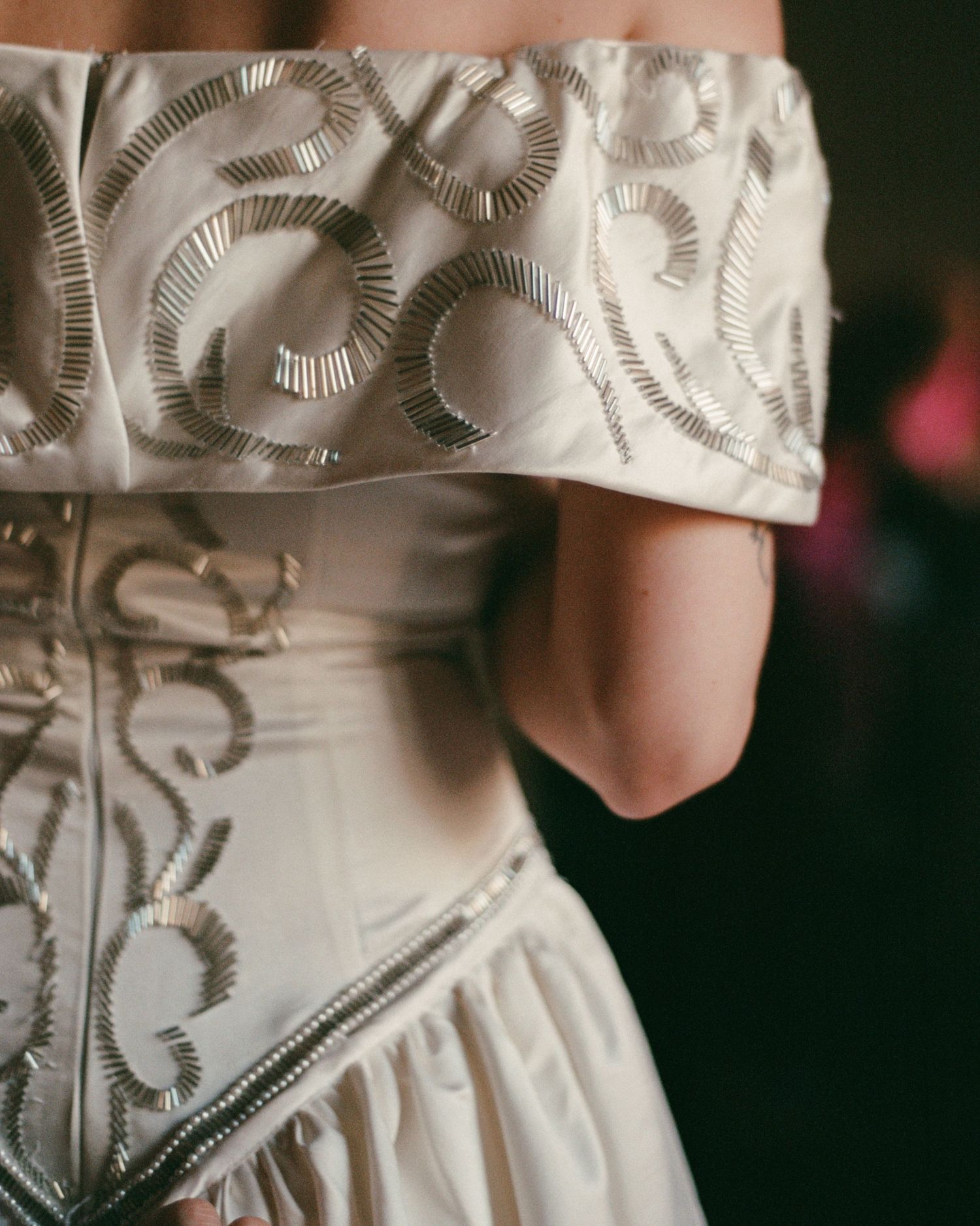 Detail shots of intricate embroidered pattern on white wedding dress fabric.