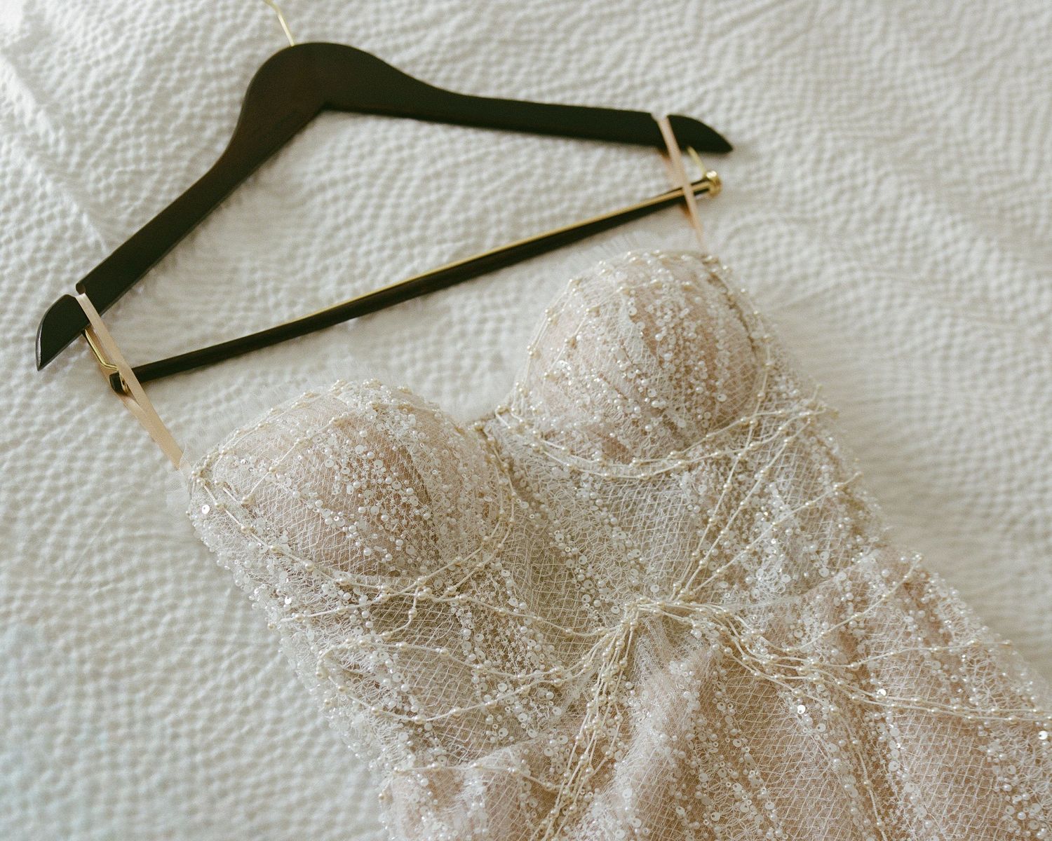 Close-up detail of delicate lace trim on a wedding dress hanger.
