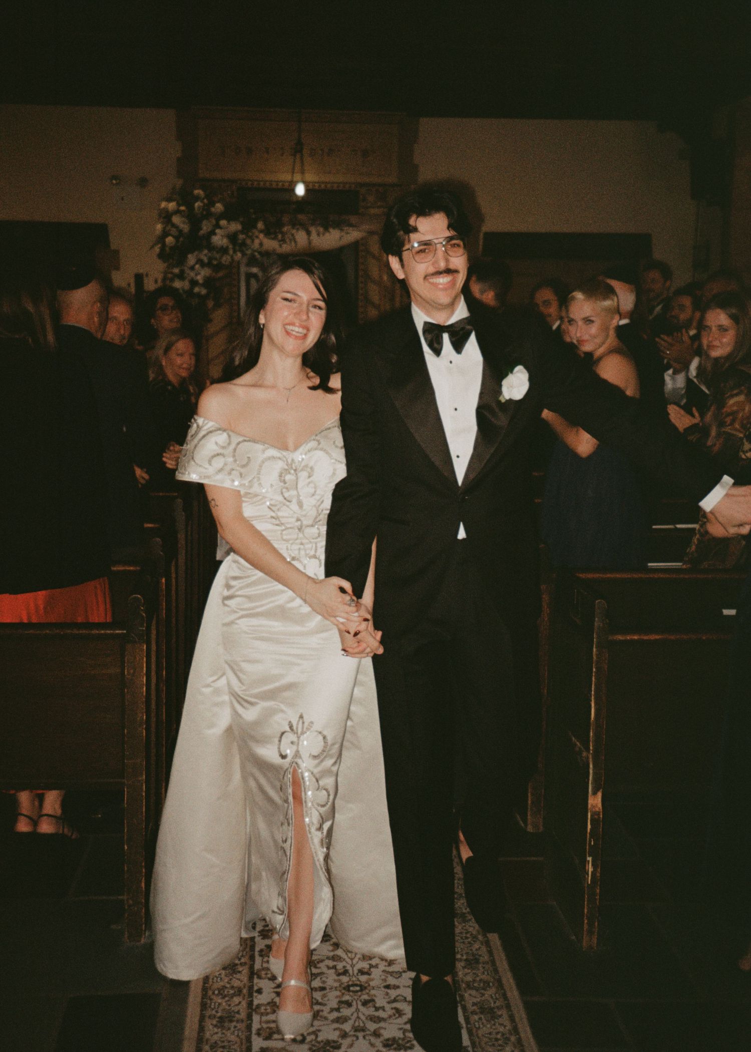 Wedding ceremony in traditional church setting with formal attire and decorations.