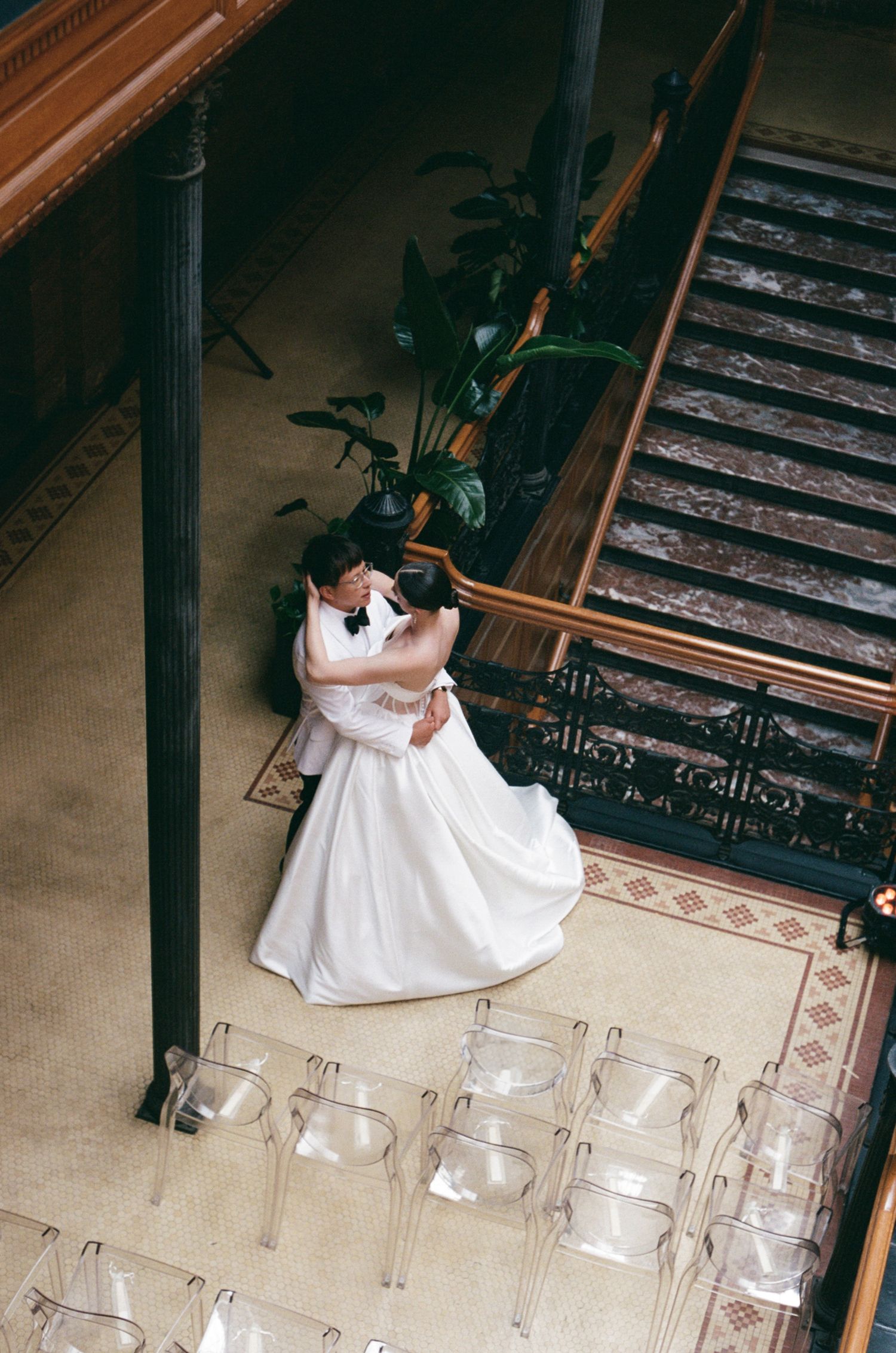 Overhead view of empty chairs arranged for a wedding ceremony with white dress in frame.
