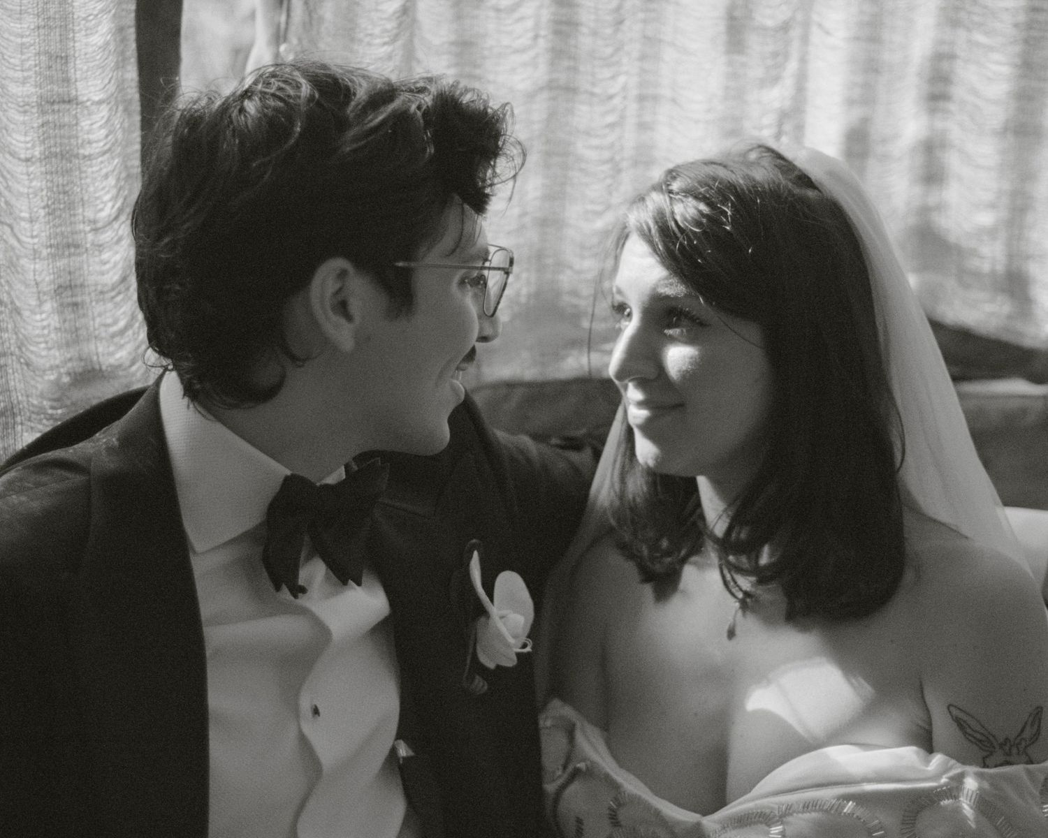 A black and white close-up of a bride and groom gazing at each other on their wedding day.