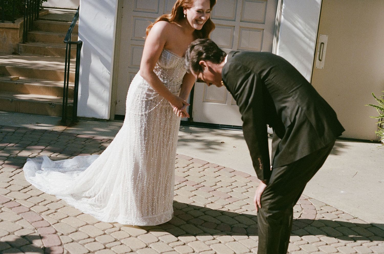 Romantic first look sequence between couple on a brick paved courtyard.