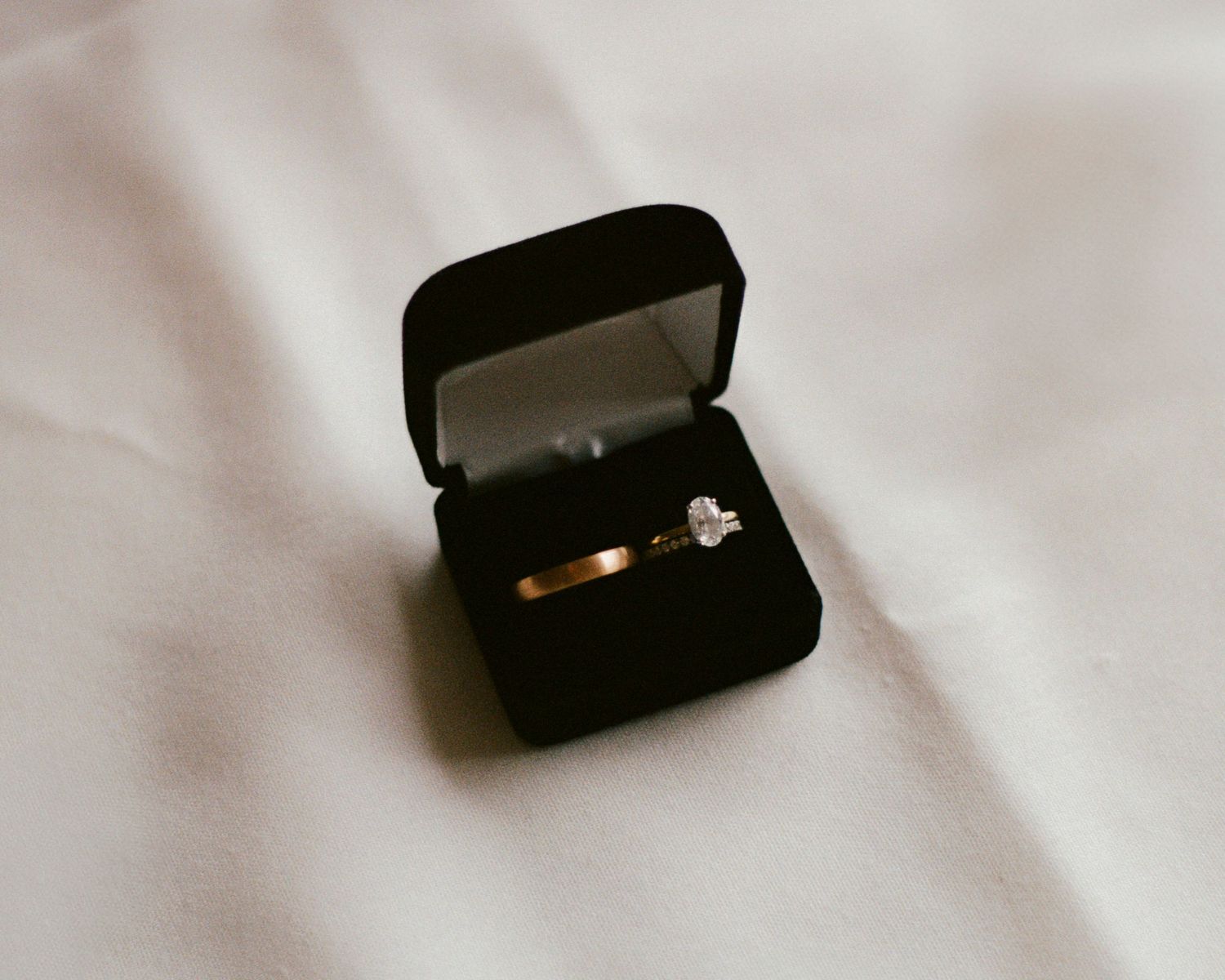 Black ring box on white fabric surface.