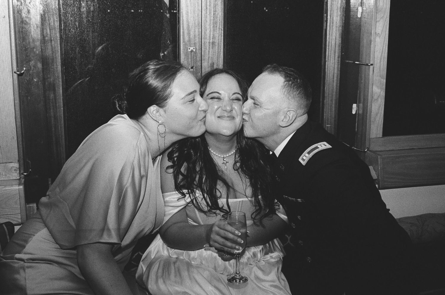 A joyful moment captured as family members share kisses during wedding festivities.