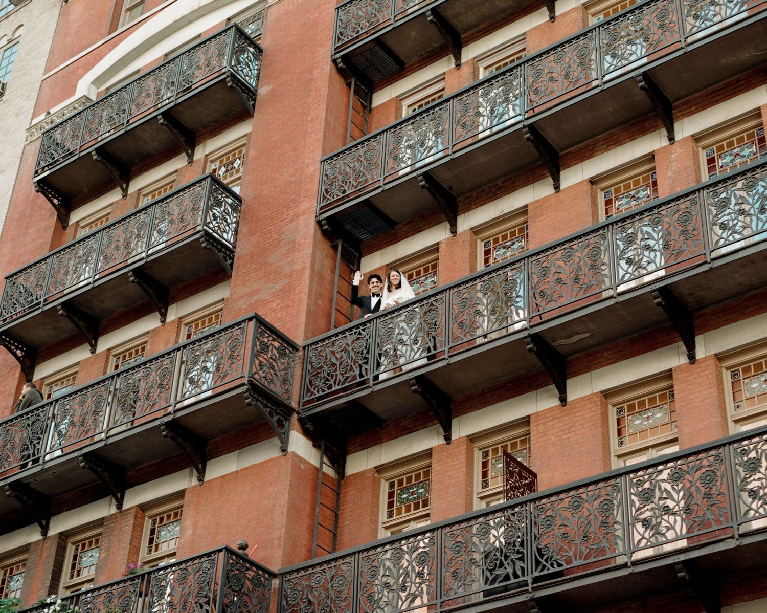 Architectural detail of a terracotta building with ornate iron balconies.