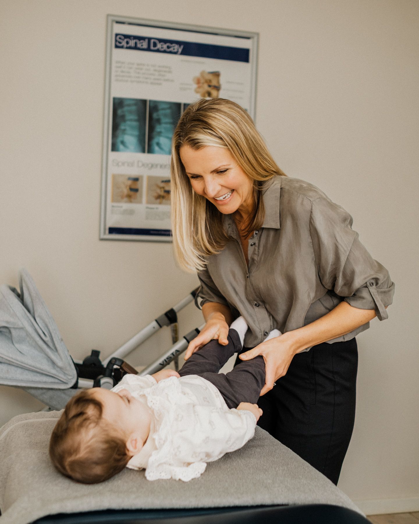 A Shoalhaven chiropractor performs spinal adjustment therapy on a patient lying on an examination table for personal branding.
