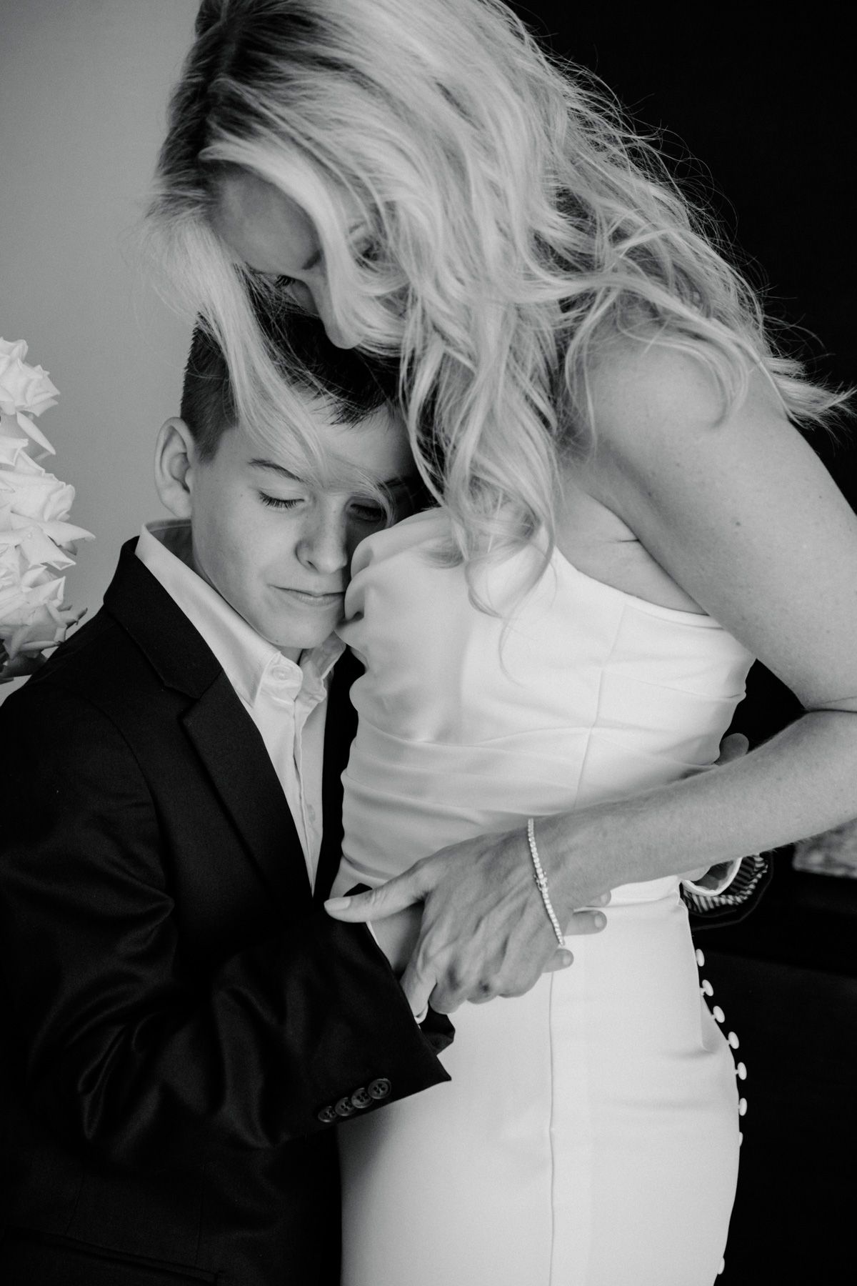 A romantic black and white photo series showing an intimate couple in formal attire embracing and sharing tender moments.