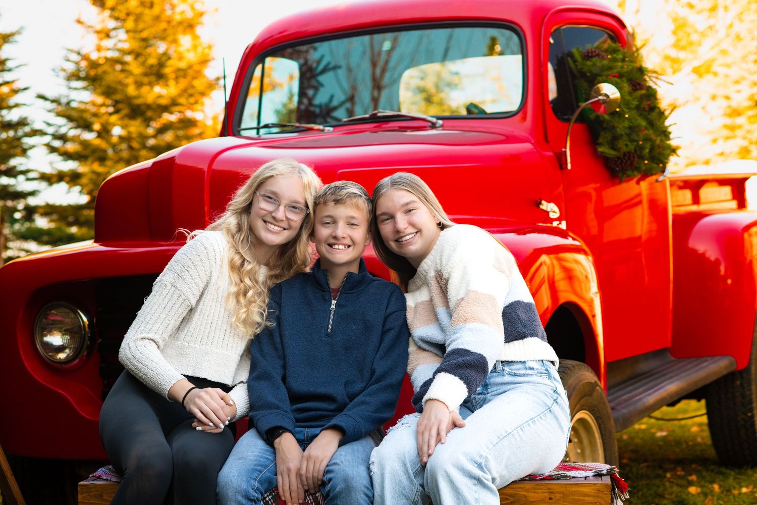 A classic red pickup truck provides a rustic backdrop for a casual outdoor photo.