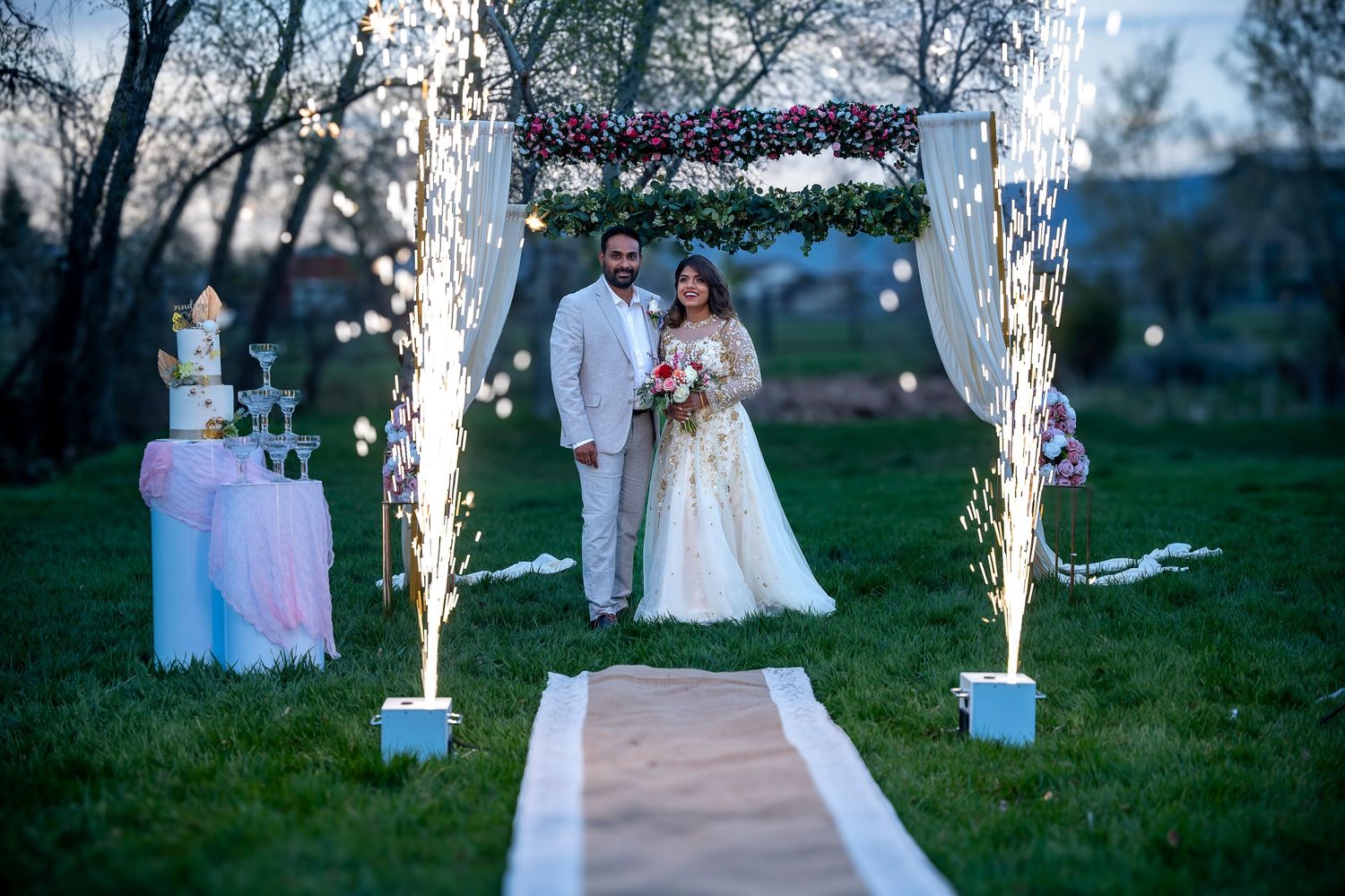 Wedding celebration with sparklers creating magical lighting effects in an outdoor evening setting.