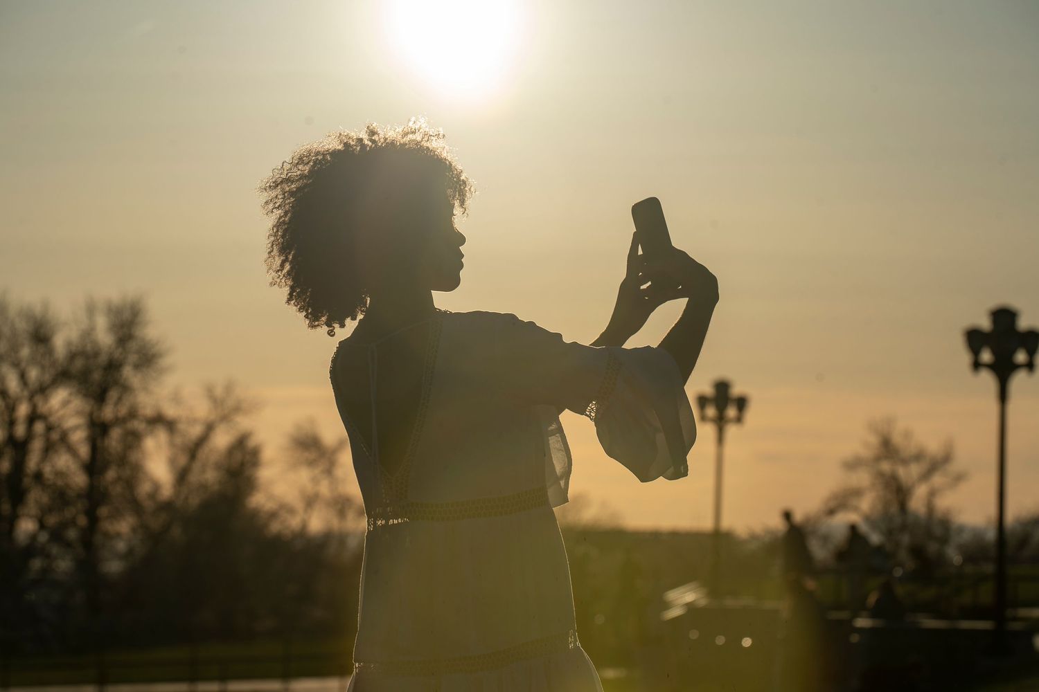 Silhouetted couple against golden sunset creating romantic backlit wedding portraits.